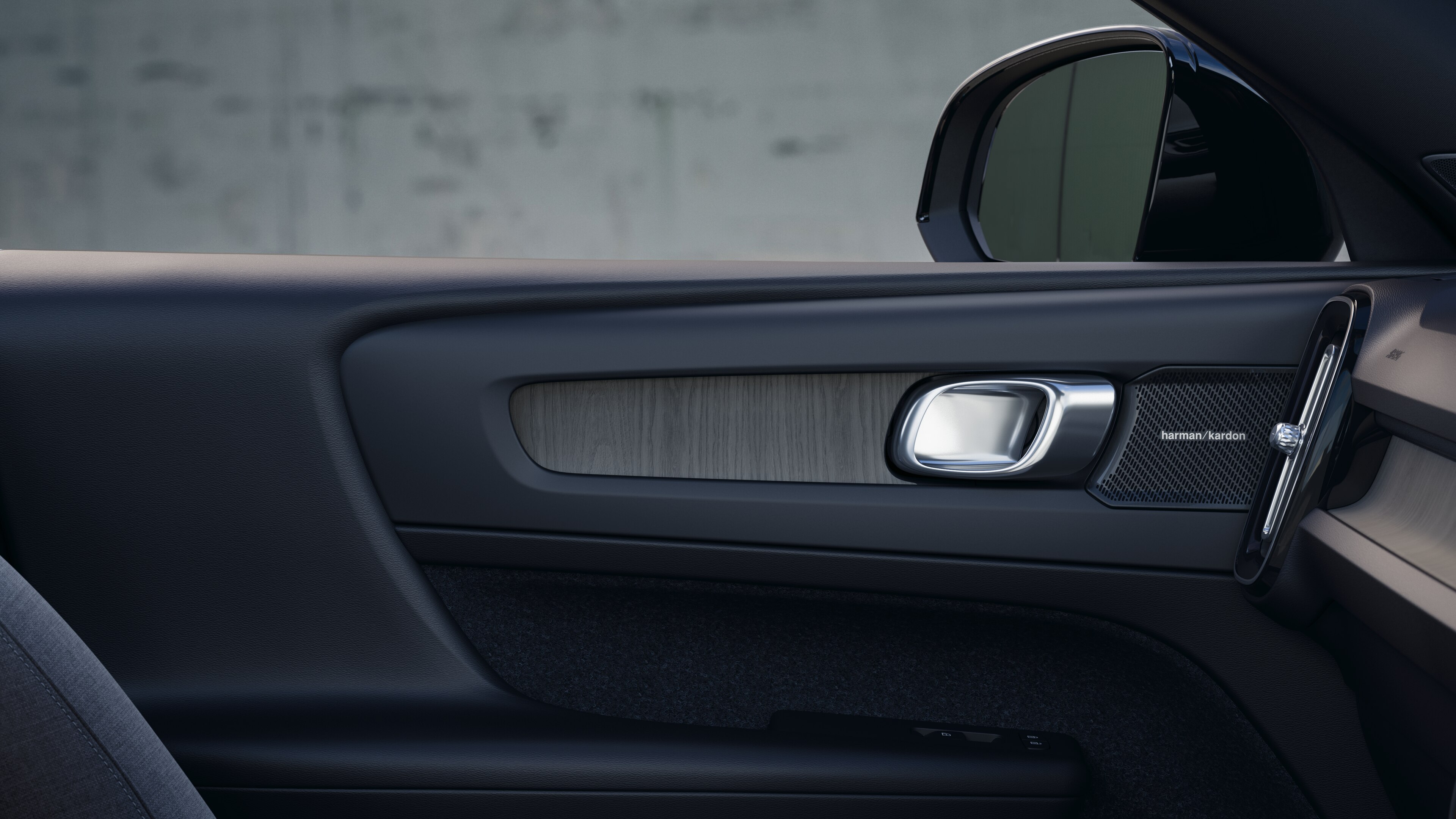 簡素なスタジオを背景に、フロントとリアの助手席、ステアリングホイール、ダッシュボード、センターコンソールを収めたボルボ車のインテリア。