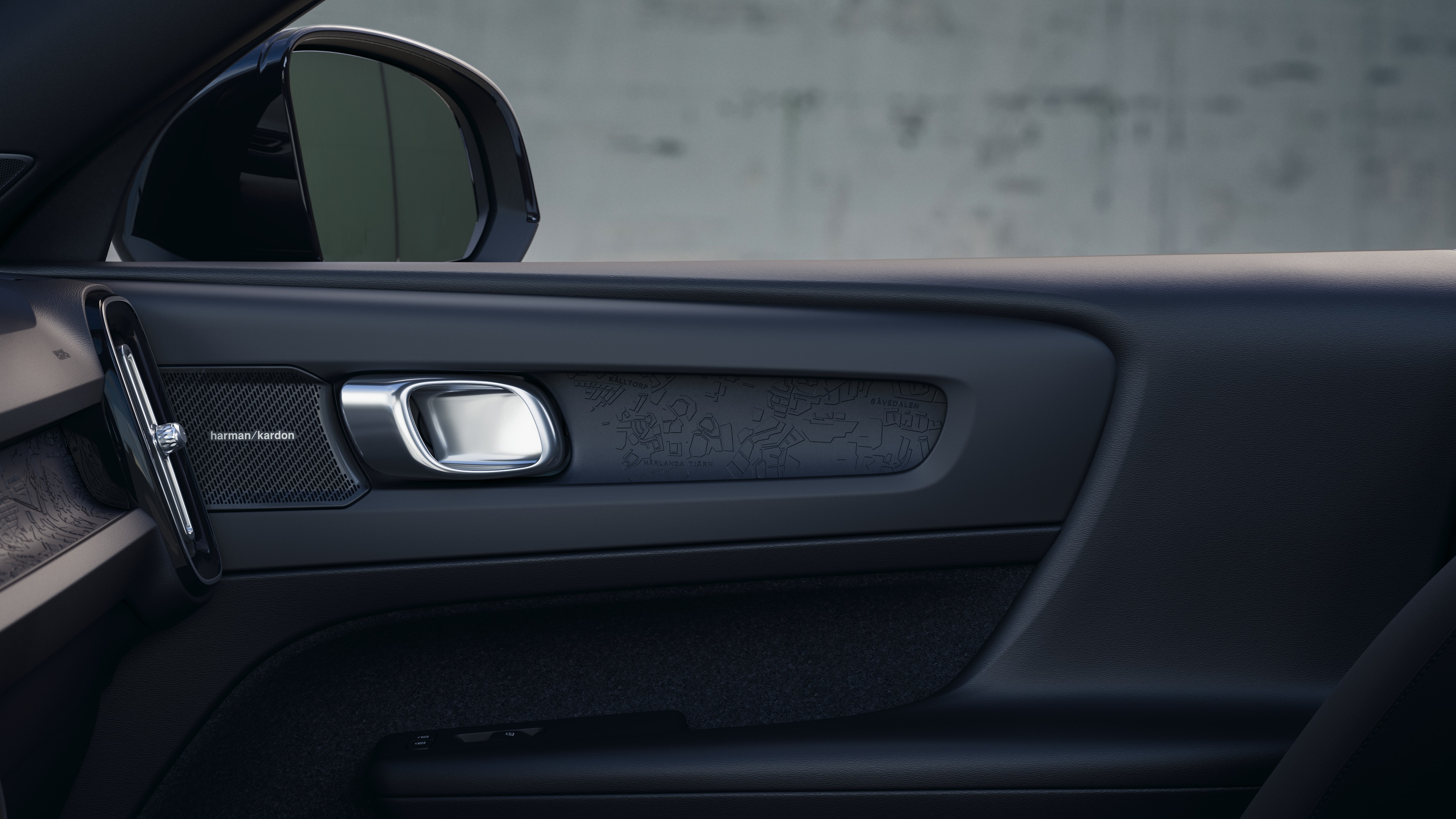 Volvo automašīnas salons ar priekšējiem un aizmugurējiem pasažieru sēdekļiem, stūri, instrumentu paneli un centrālo konsoli uz vienkārša studijas fona.