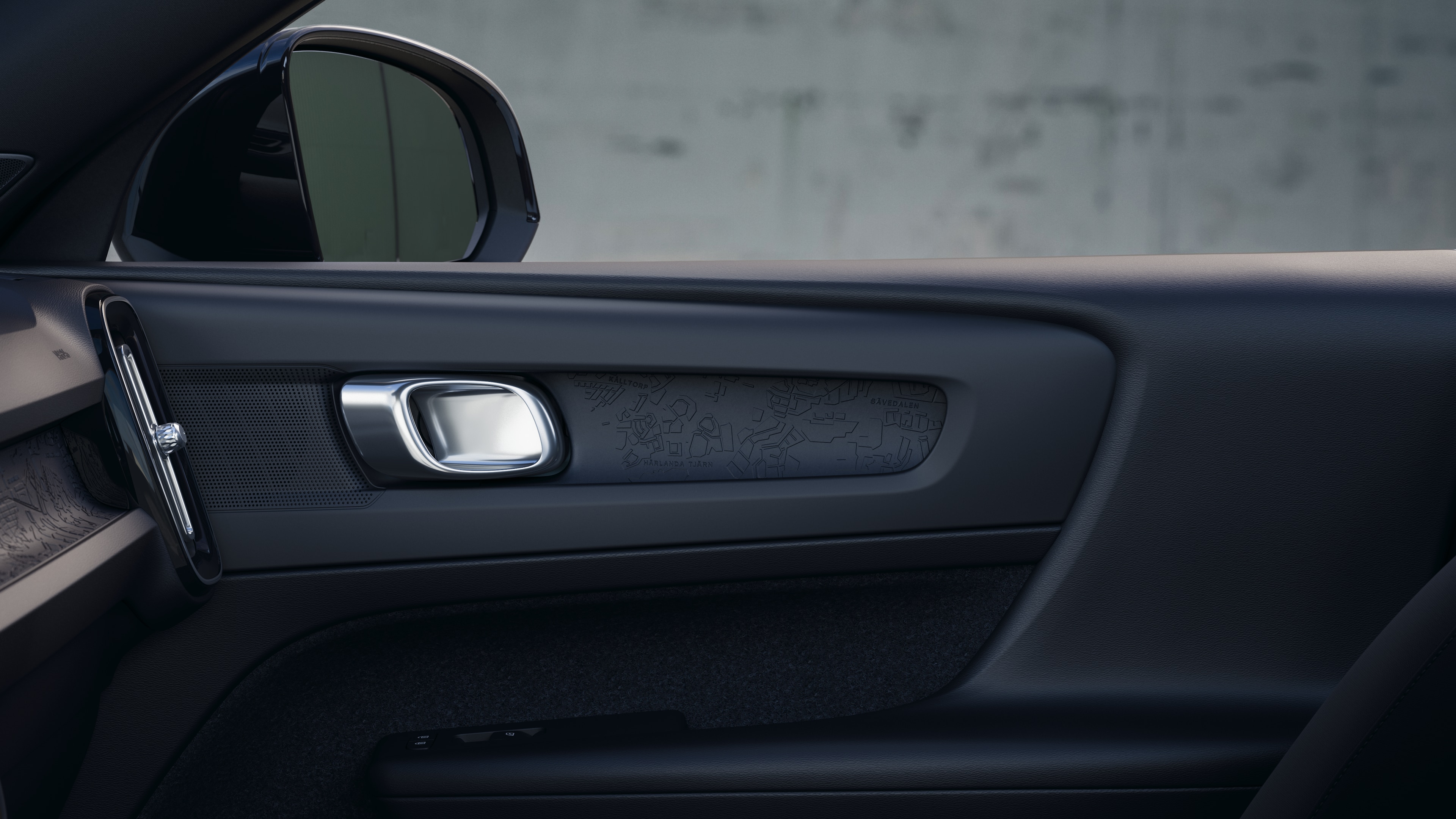 Het interieur van een Volvo met de passagiersstoelen voor- en achterin, het stuur, het dashboard en de middenconsole tegen een effen studioachtergrond.