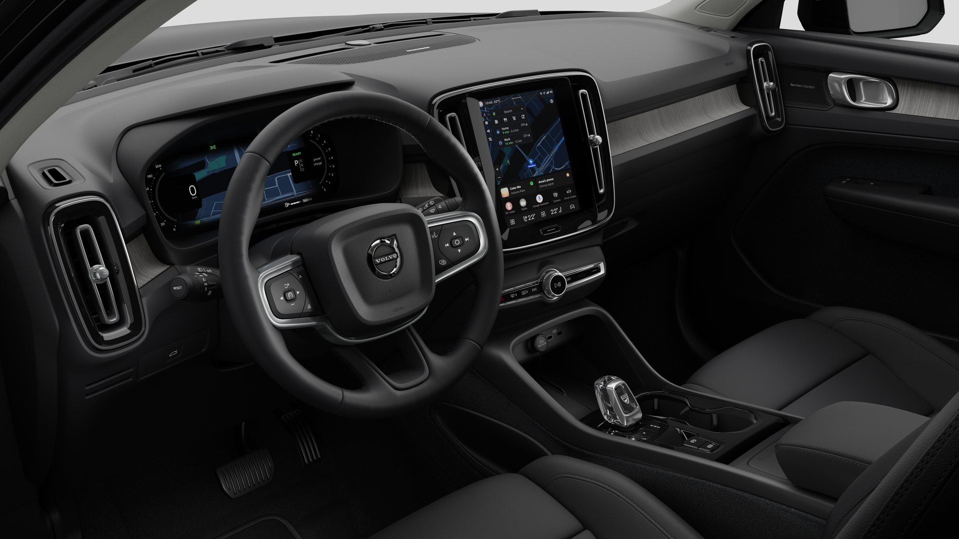 Vue intérieure d’une Volvo montrant le tableau de bord, le volant, la console centrale et l’écran d’affichage numérique sur un fond de studio uni.