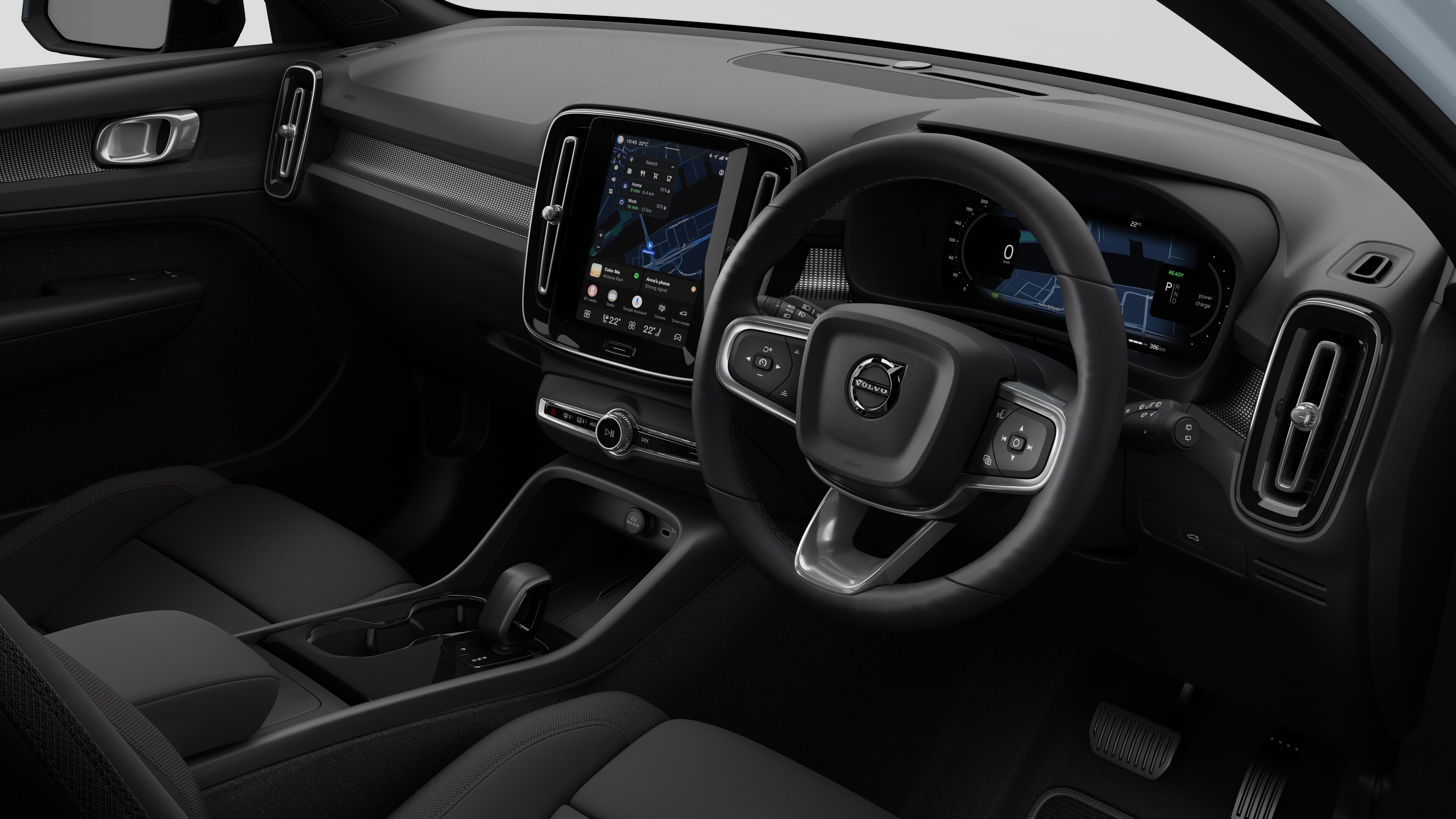Interior view of a Volvo car showing the dashboard, steering wheel, center console, and digital display screen in a plain studio background.