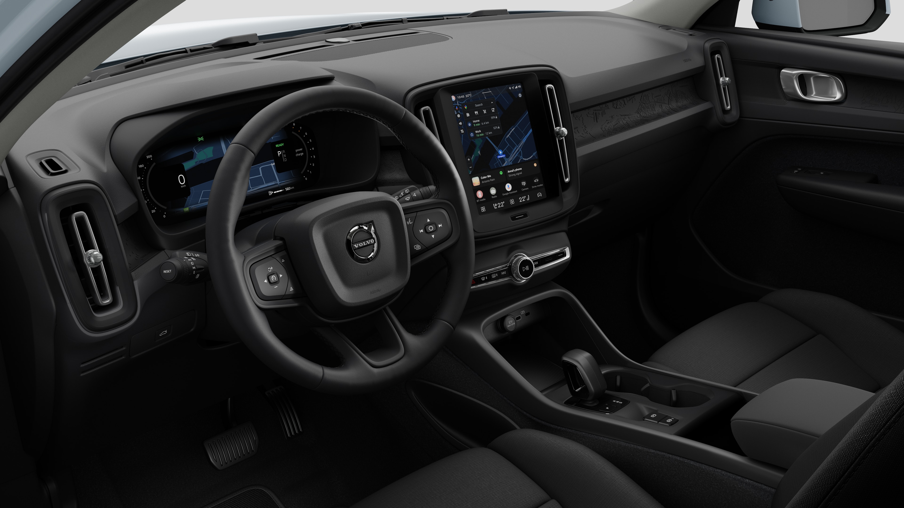 Innenansicht eines Volvo mit Armaturenbrett, Lenkrad, Mittelkonsole und digitalem Bildschirm in einem schlichten Studiohintergrund.