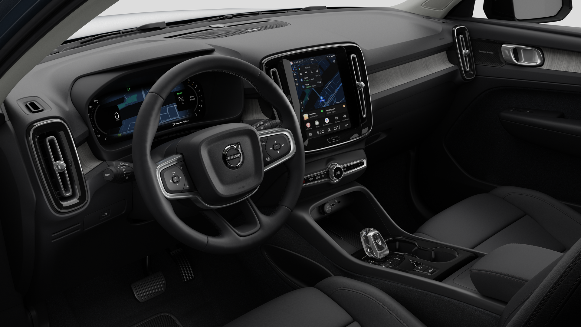 Vue intérieure d’une Volvo montrant le tableau de bord, le volant, la console centrale et l’écran d’affichage numérique sur un fond de studio uni.