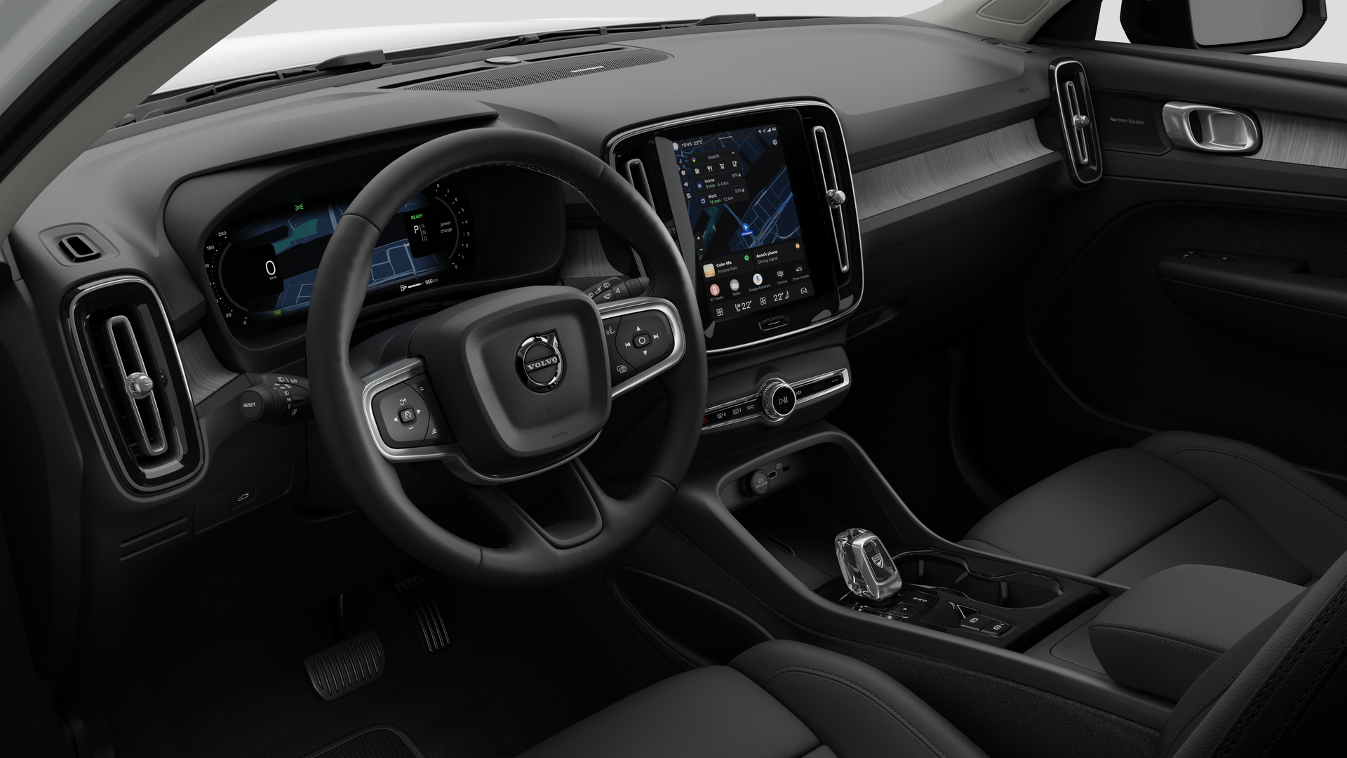 Vue intérieure d’une Volvo montrant le tableau de bord, le volant, la console centrale et l’écran d’affichage numérique sur un fond de studio uni.