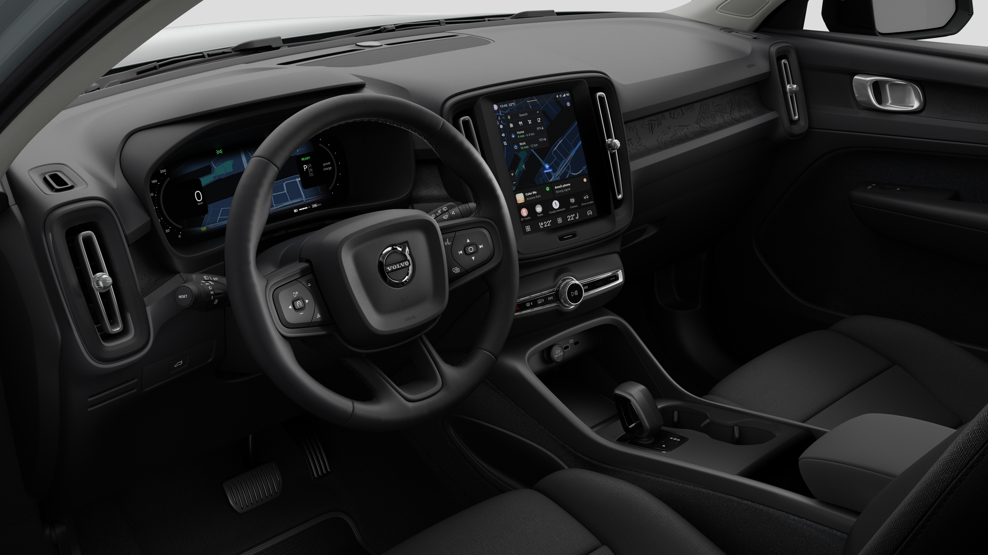 Vue intérieure d’une Volvo montrant le tableau de bord, le volant, la console centrale et l’écran d’affichage numérique dans un fond de studio uni.