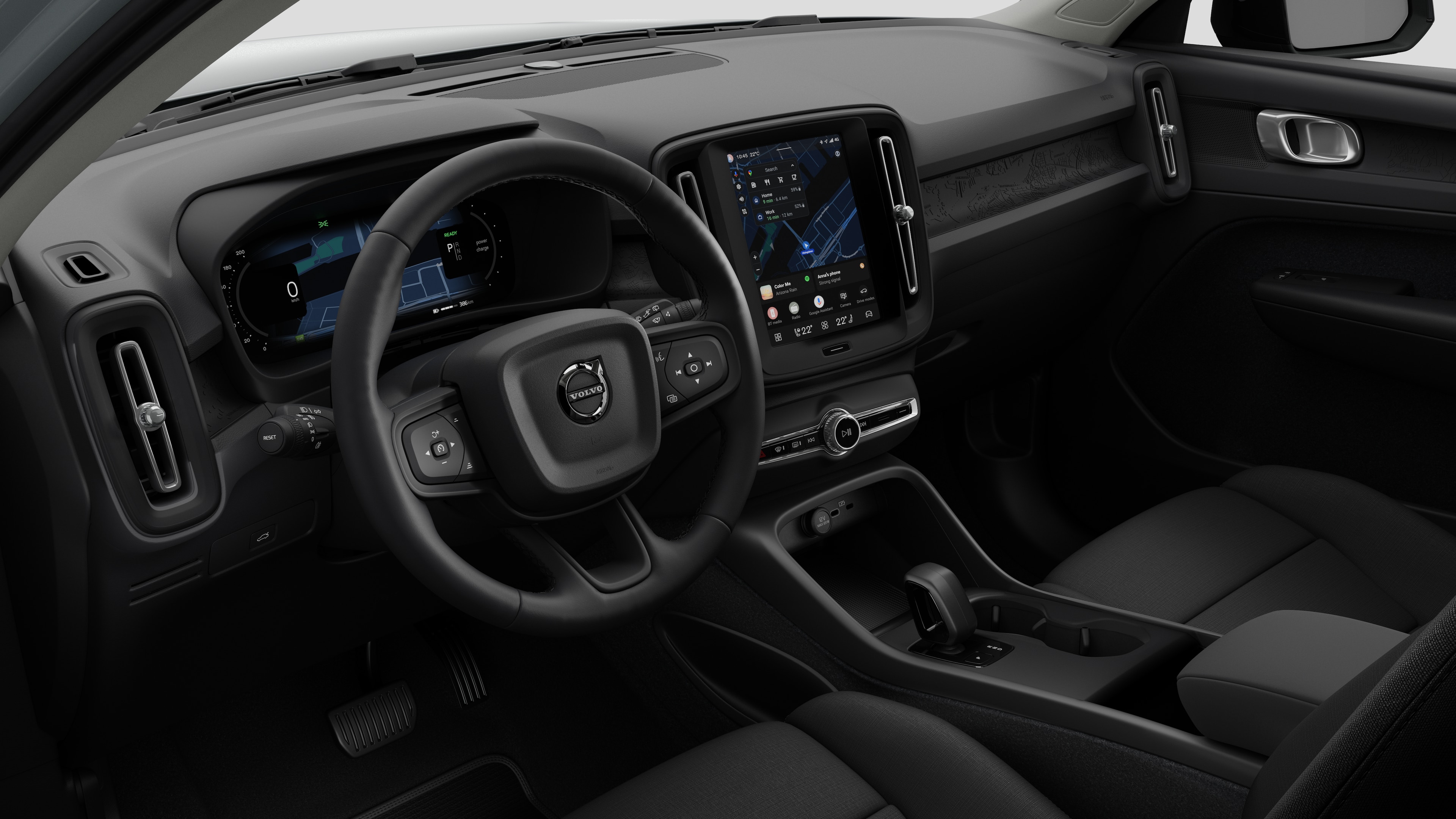 Vue intérieure d’une Volvo montrant le tableau de bord, le volant, la console centrale et l’écran d’affichage numérique dans un fond de studio uni.