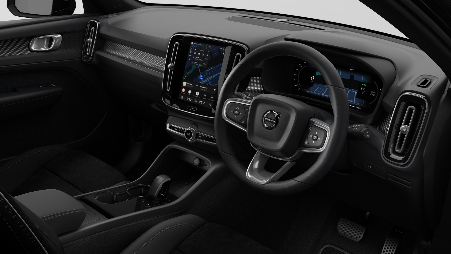 Interior view of a Volvo car showing the dashboard, steering wheel, center console, and digital display screen in a plain studio background.