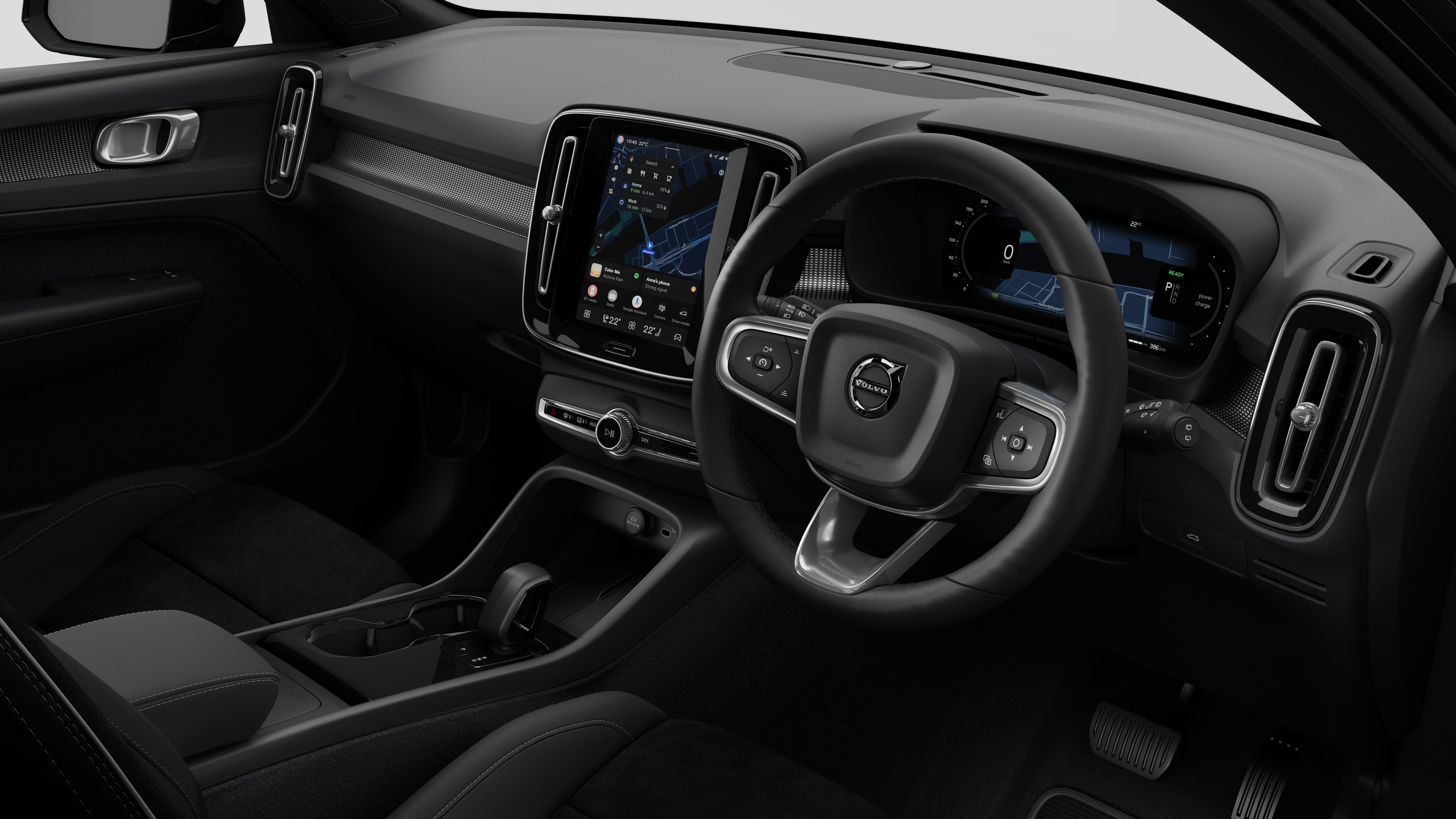 Interior view of a Volvo car showing the dashboard, steering wheel, center console, and digital display screen in a plain studio background.