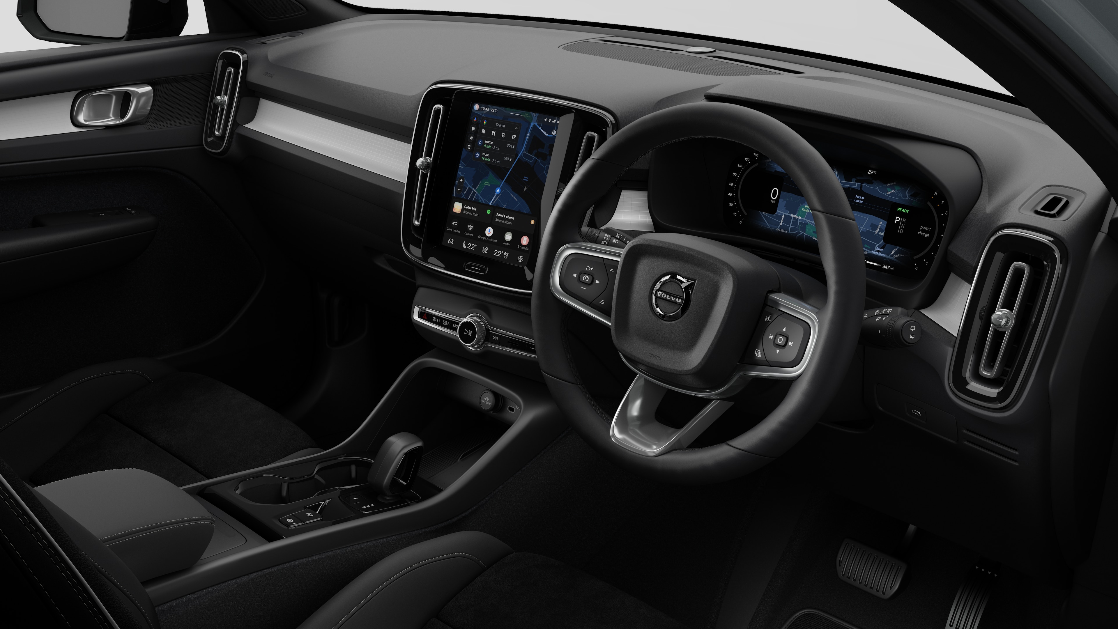 Interior view of a Volvo car showing the dashboard, steering wheel, centre console, and digital display screen in a plain studio background.