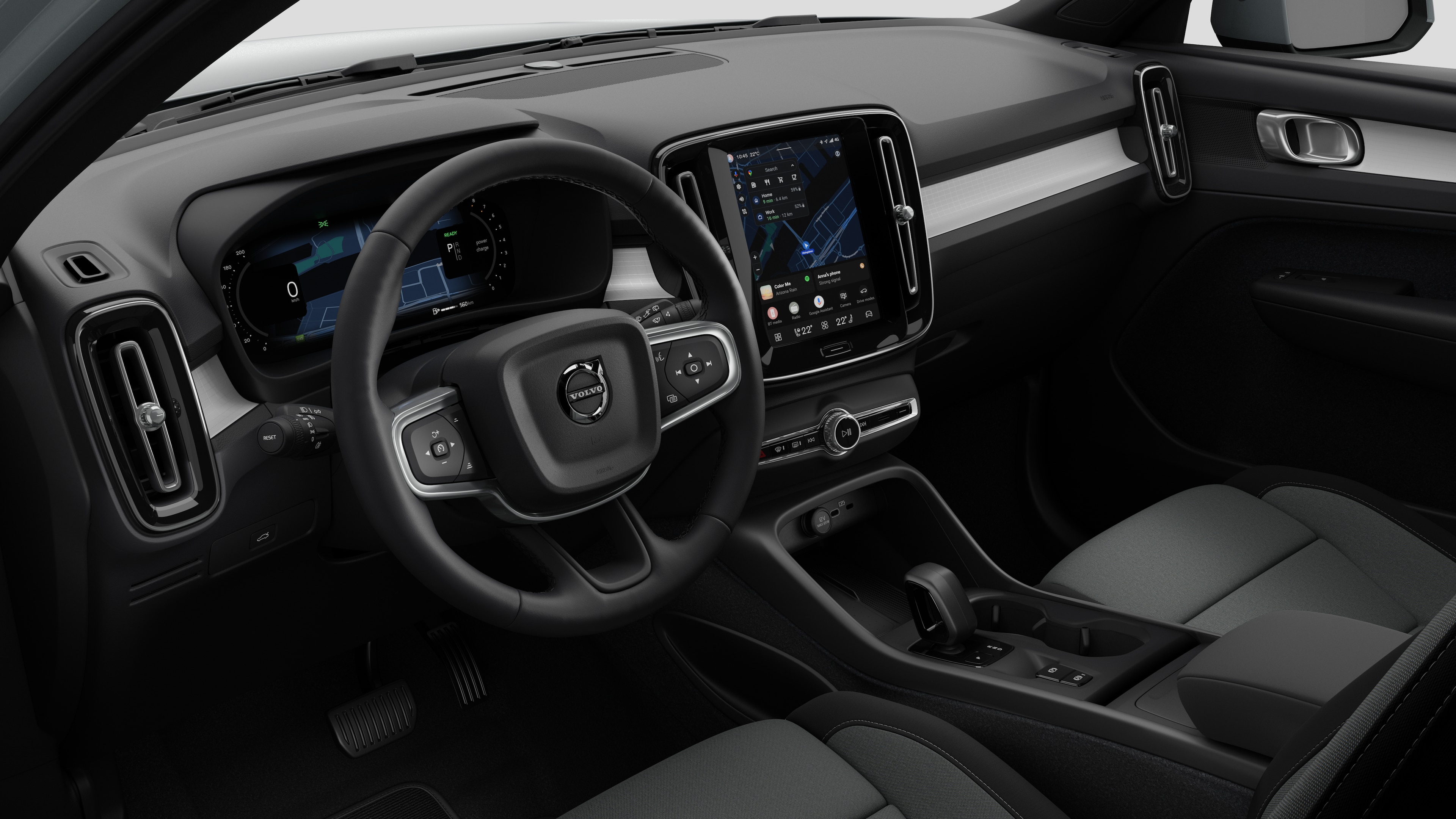 Vue intérieure d’une Volvo montrant le tableau de bord, le volant, la console centrale et l’écran d’affichage numérique dans un fond de studio uni.