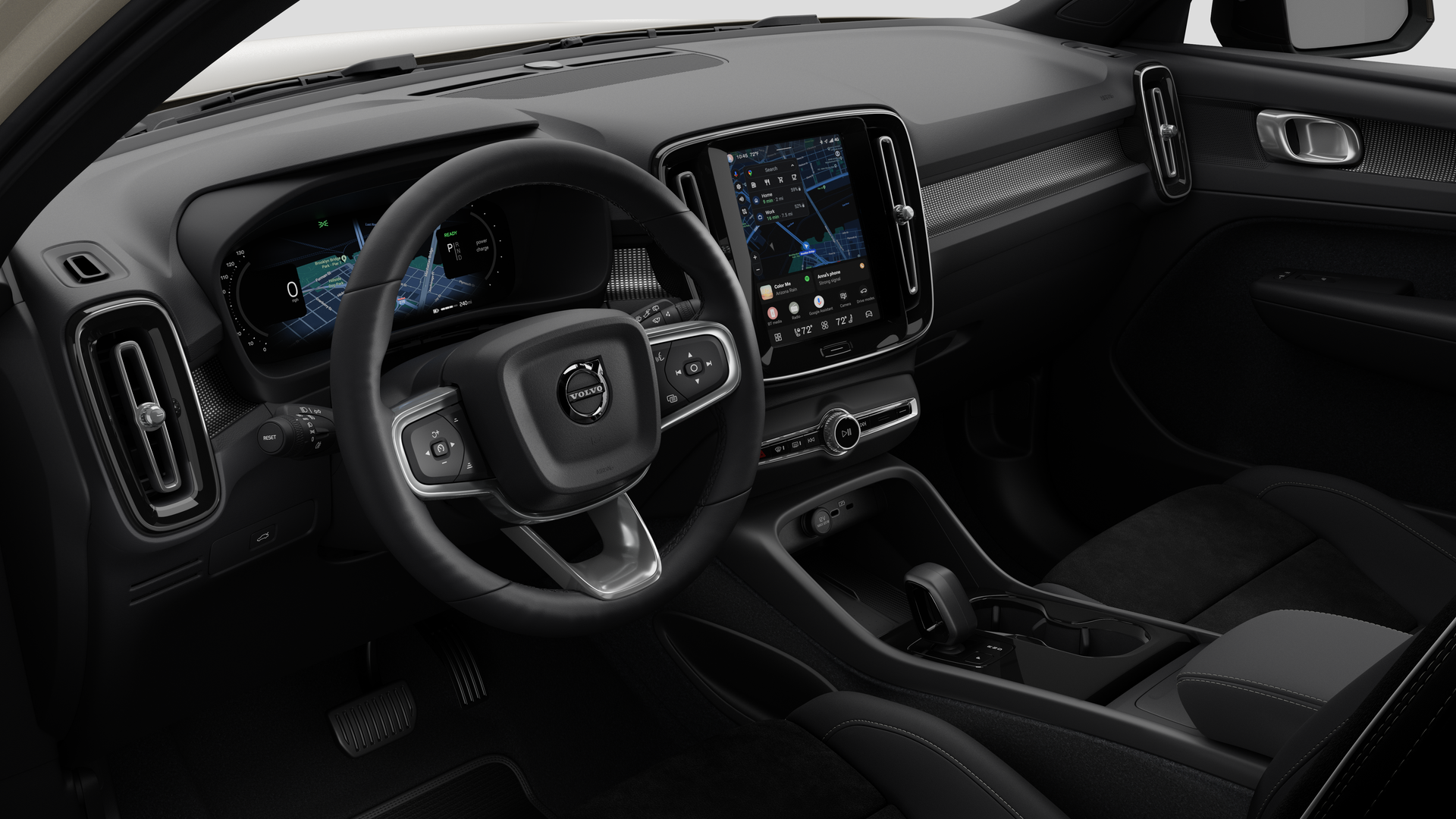 Interior view of a Volvo car showing the dashboard, steering wheel, center console, and digital display screen in a plain studio background.