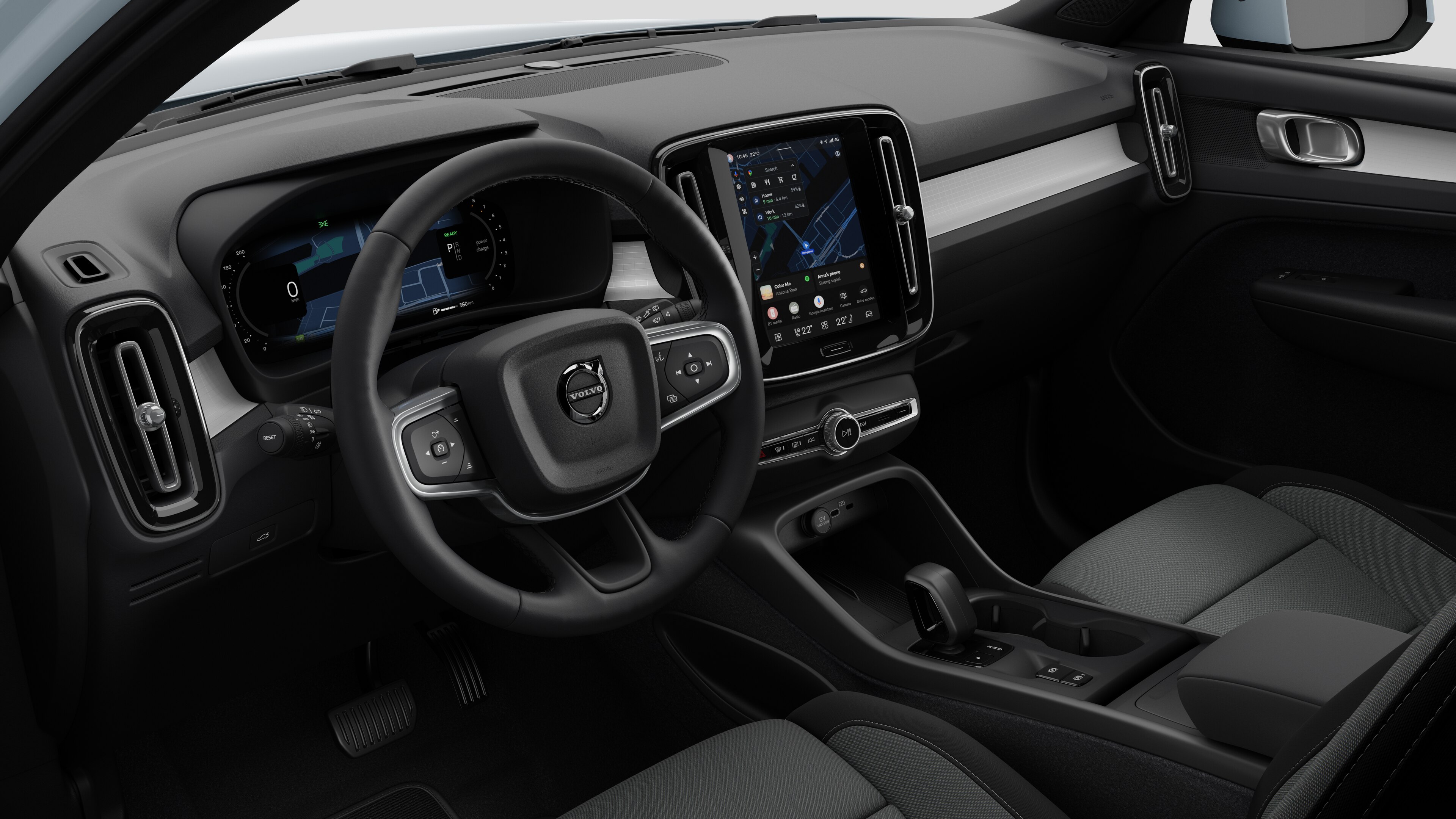 Vue intérieure d’une Volvo montrant le tableau de bord, le volant, la console centrale et l’écran d’affichage numérique sur un fond de studio uni.