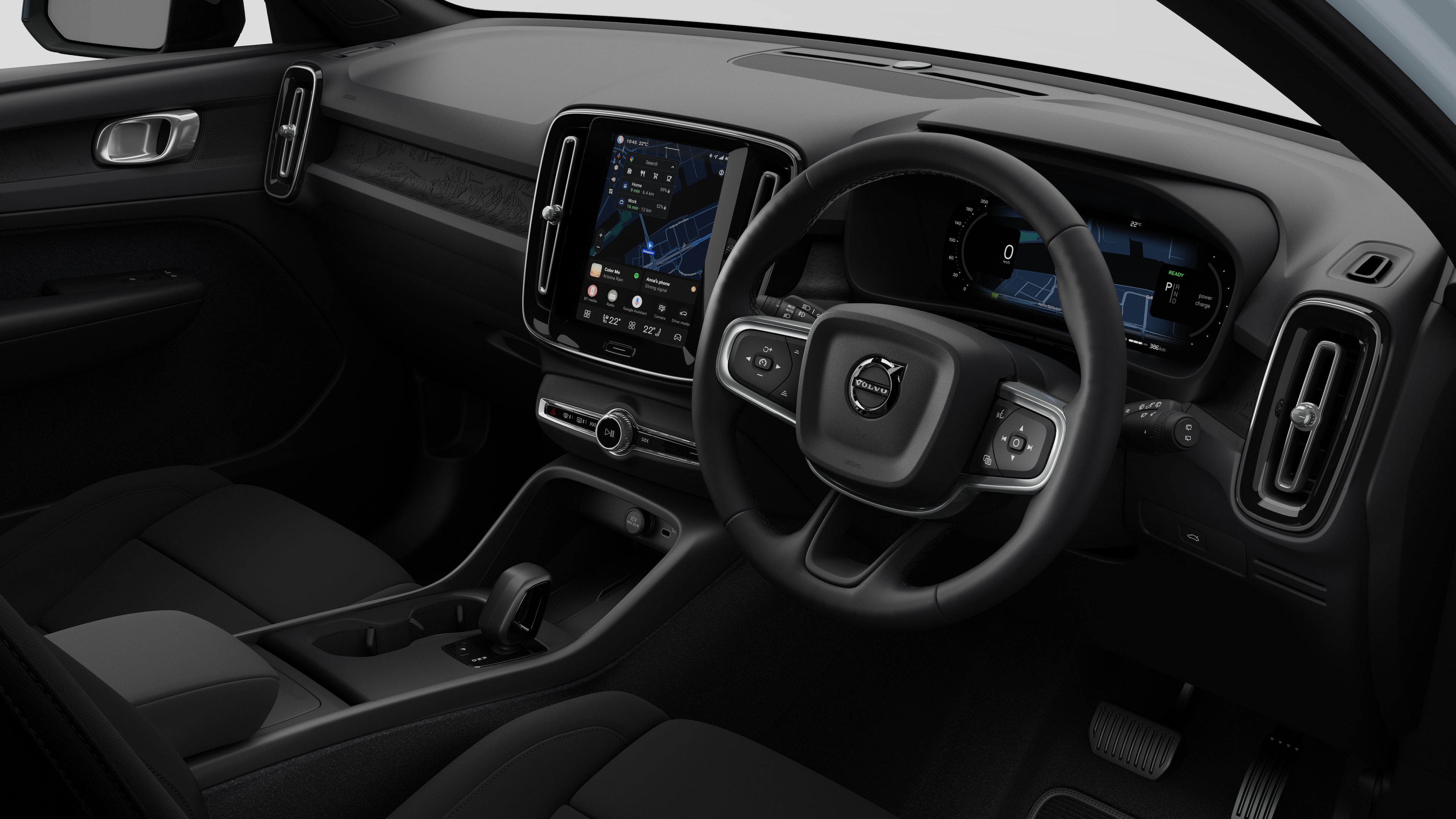 Interior view of a Volvo car showing the dashboard, steering wheel, center console, and digital display screen in a plain studio background.
