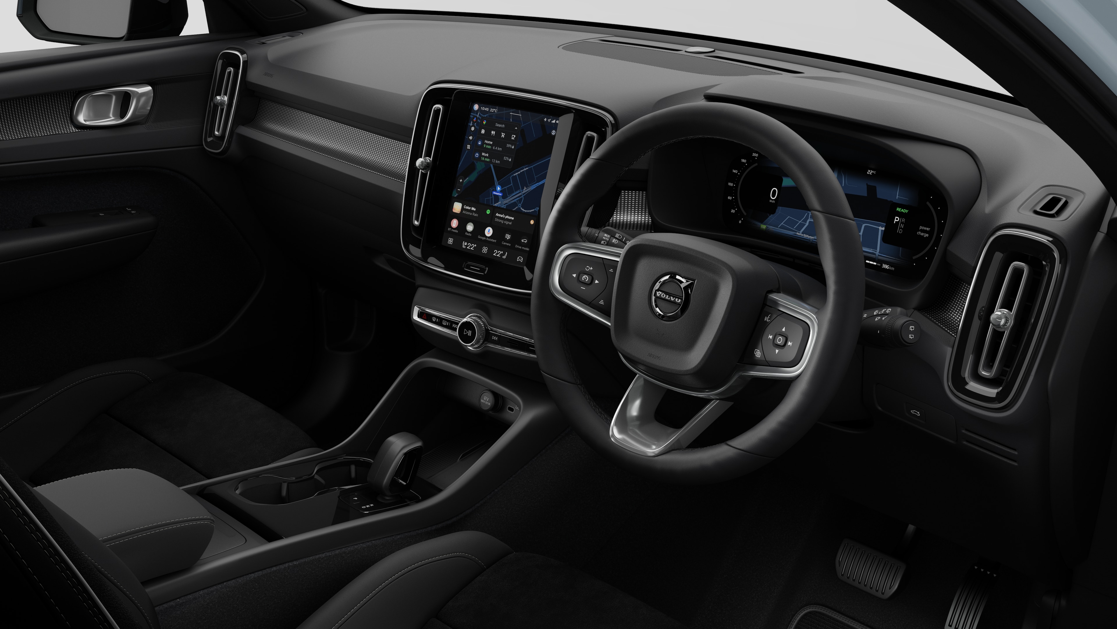 Interior view of a Volvo car showing the dashboard, steering wheel, center console, and digital display screen in a plain studio background.