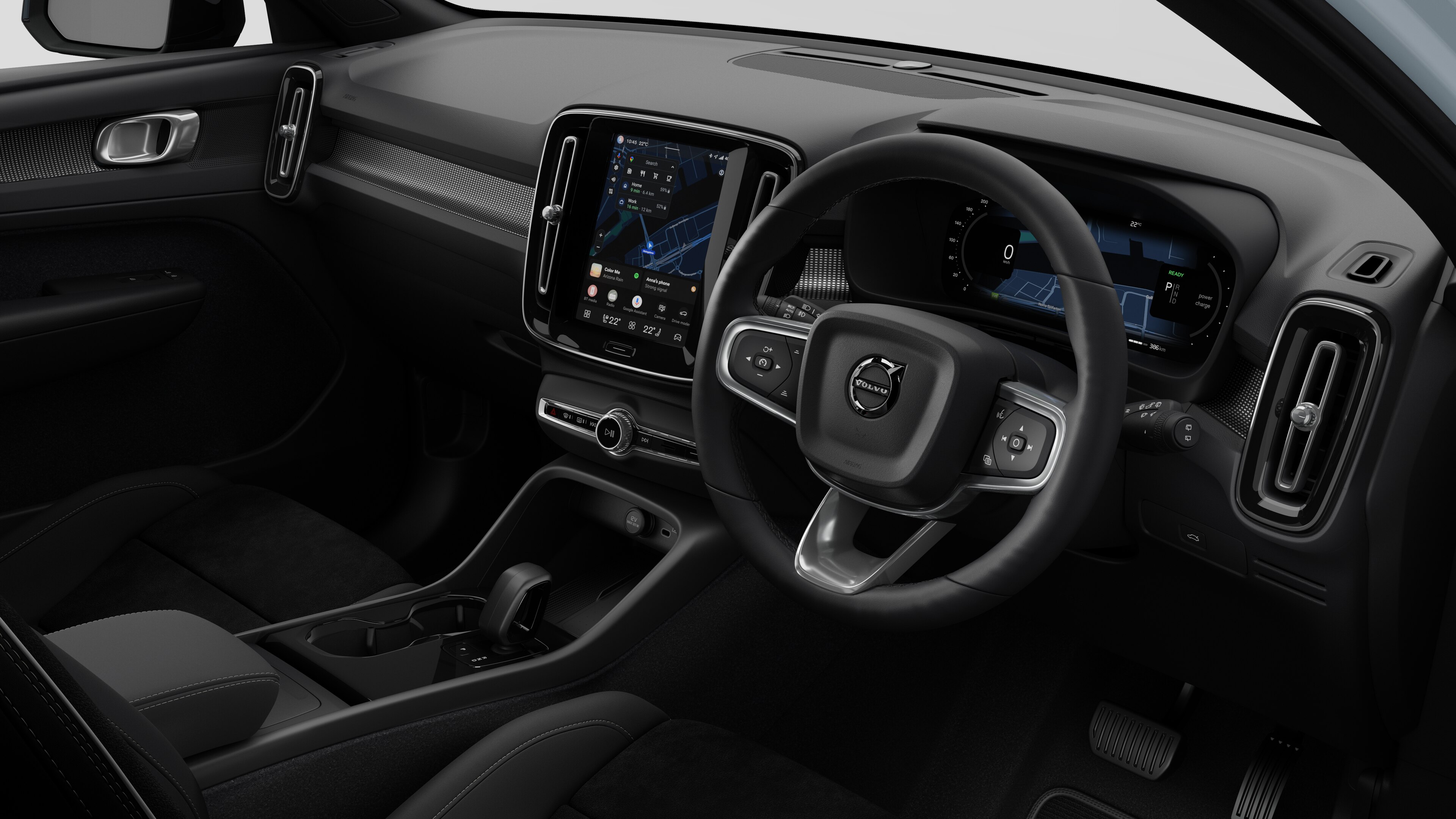 Interior view of a Volvo car showing the dashboard, steering wheel, center console, and digital display screen in a plain studio background.