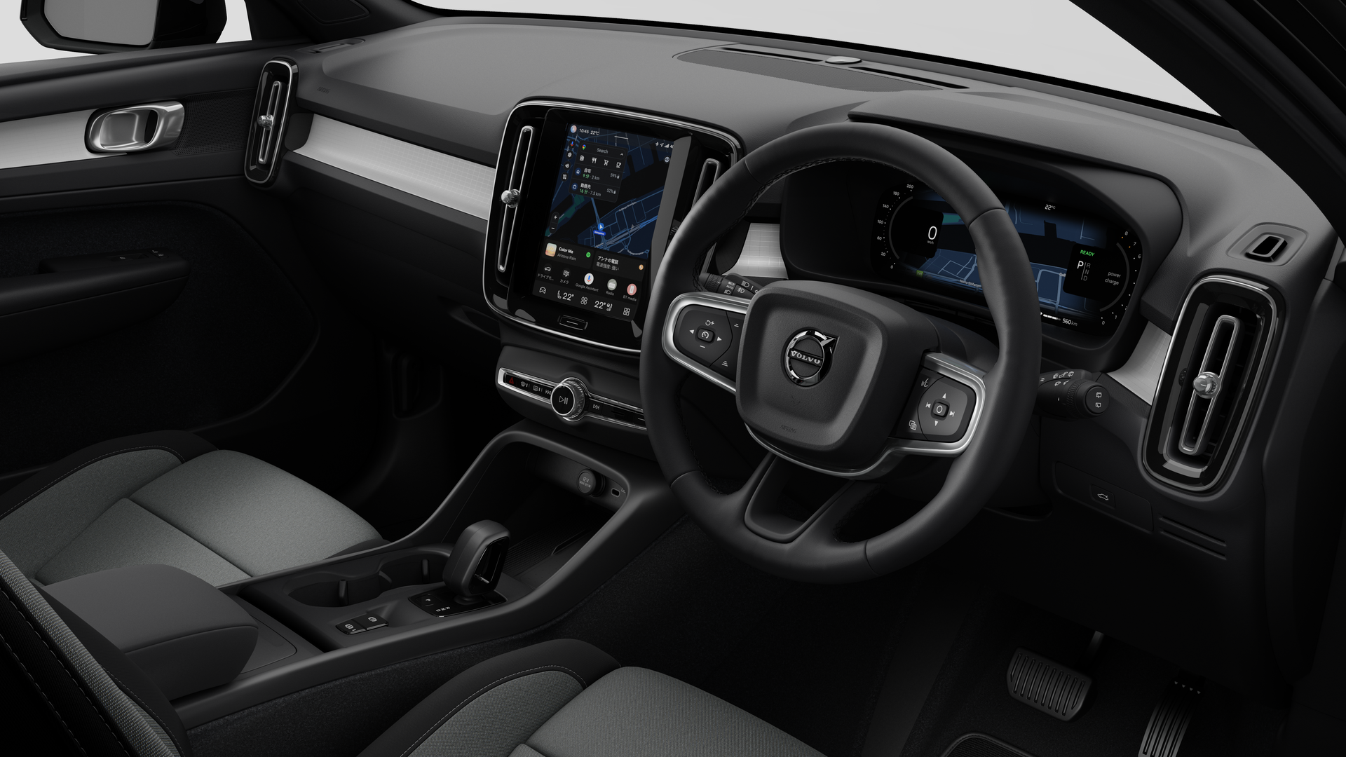 簡素なスタジオ背景にダッシュボード、ステアリングホイール、センターコンソール、デジタルディスプレイ画面を映し出すボルボ車のインテリア画像。