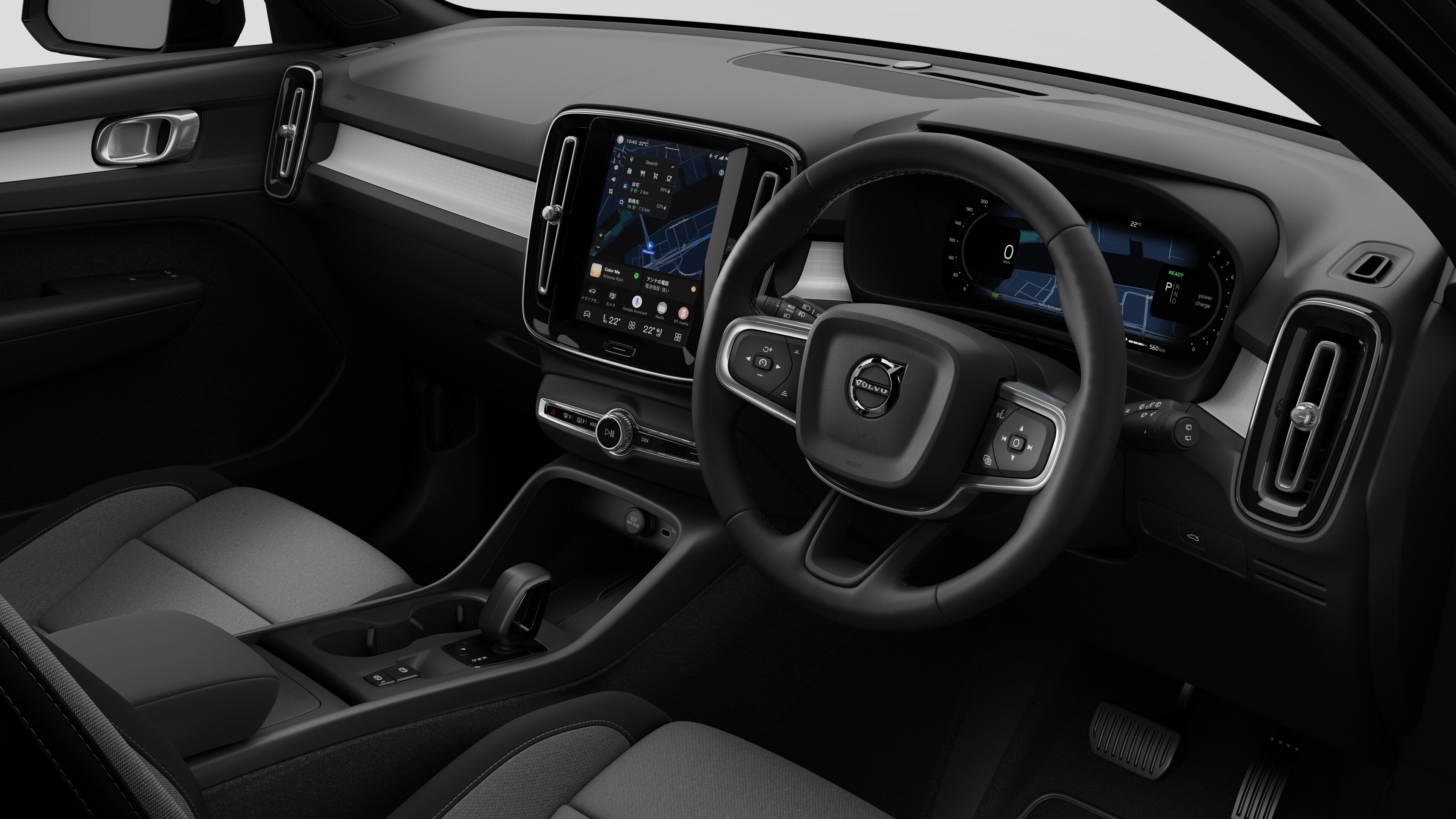 簡素なスタジオ背景にダッシュボード、ステアリングホイール、センターコンソール、デジタルディスプレイ画面を映し出すボルボ車のインテリア画像。