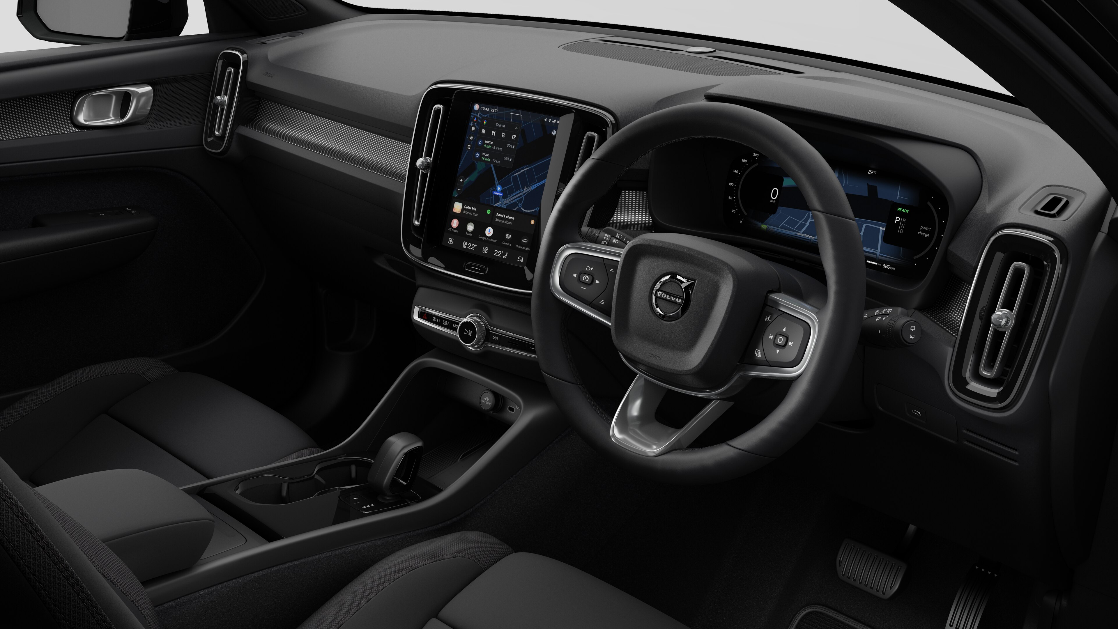 Interior view of a Volvo car showing the dashboard, steering wheel, center console, and digital display screen in a plain studio background.