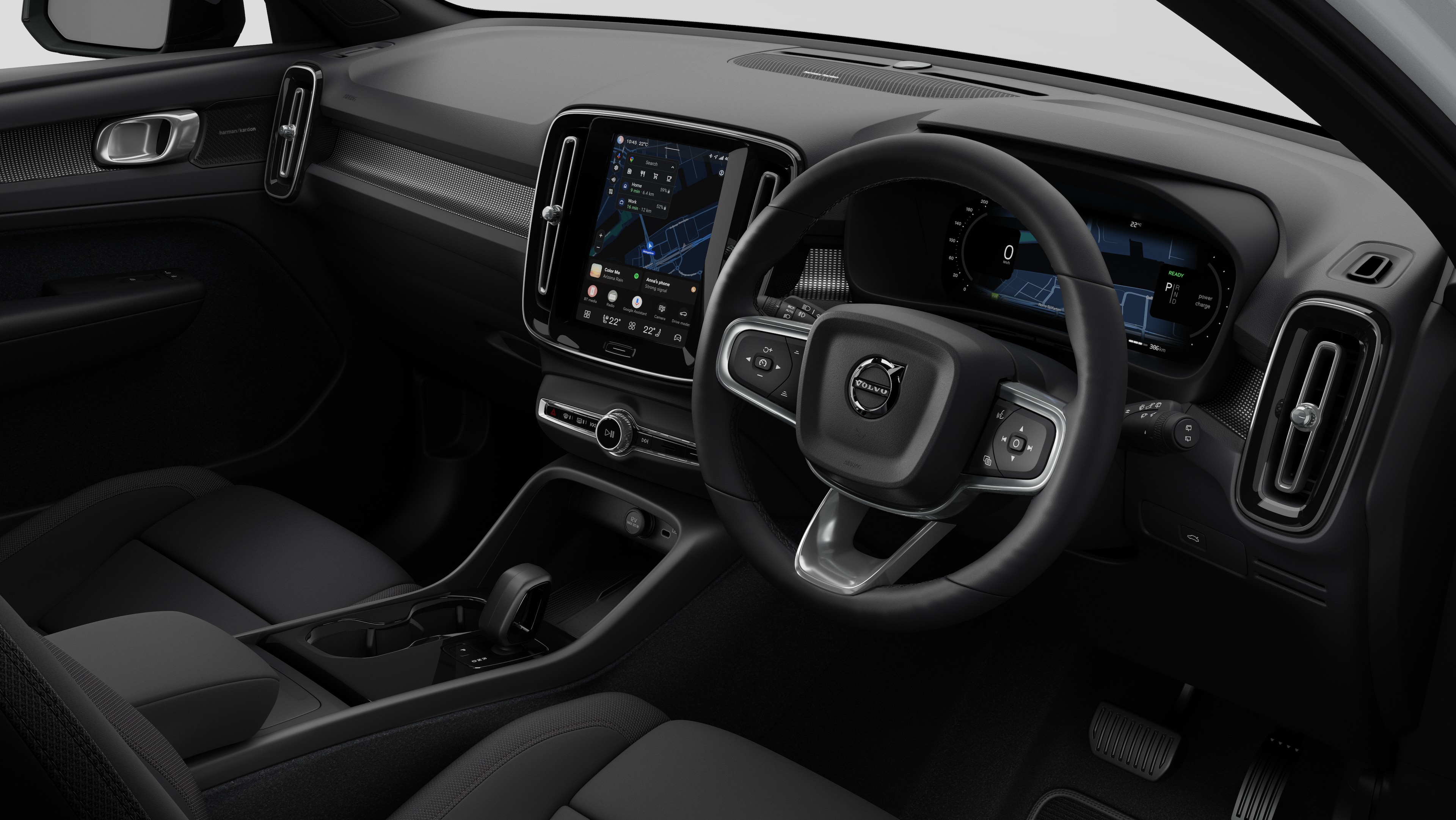 Interior view of a Volvo car showing the dashboard, steering wheel, center console, and digital display screen in a plain studio background.