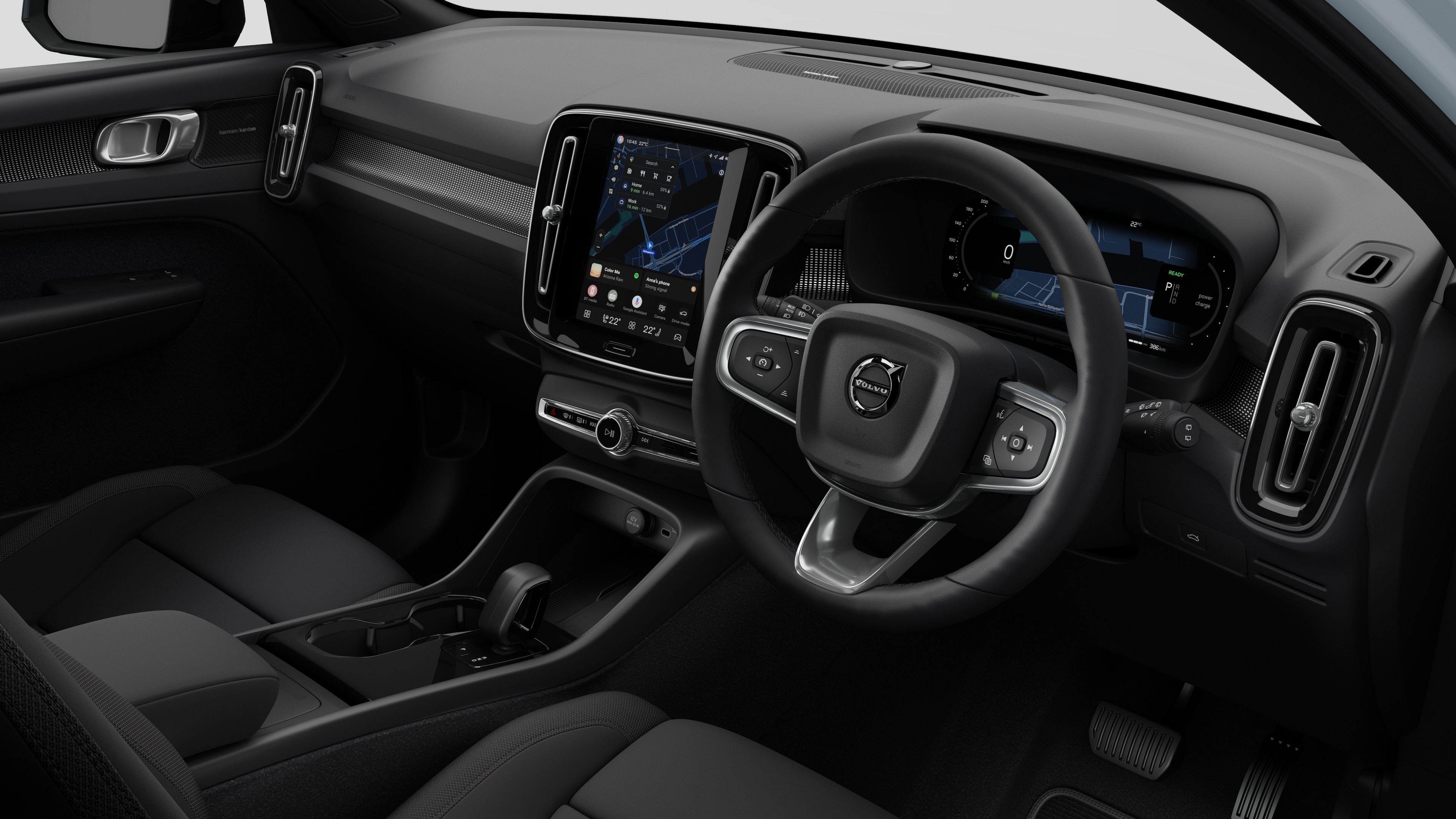 Interior view of a Volvo car showing the dashboard, steering wheel, center console, and digital display screen in a plain studio background.