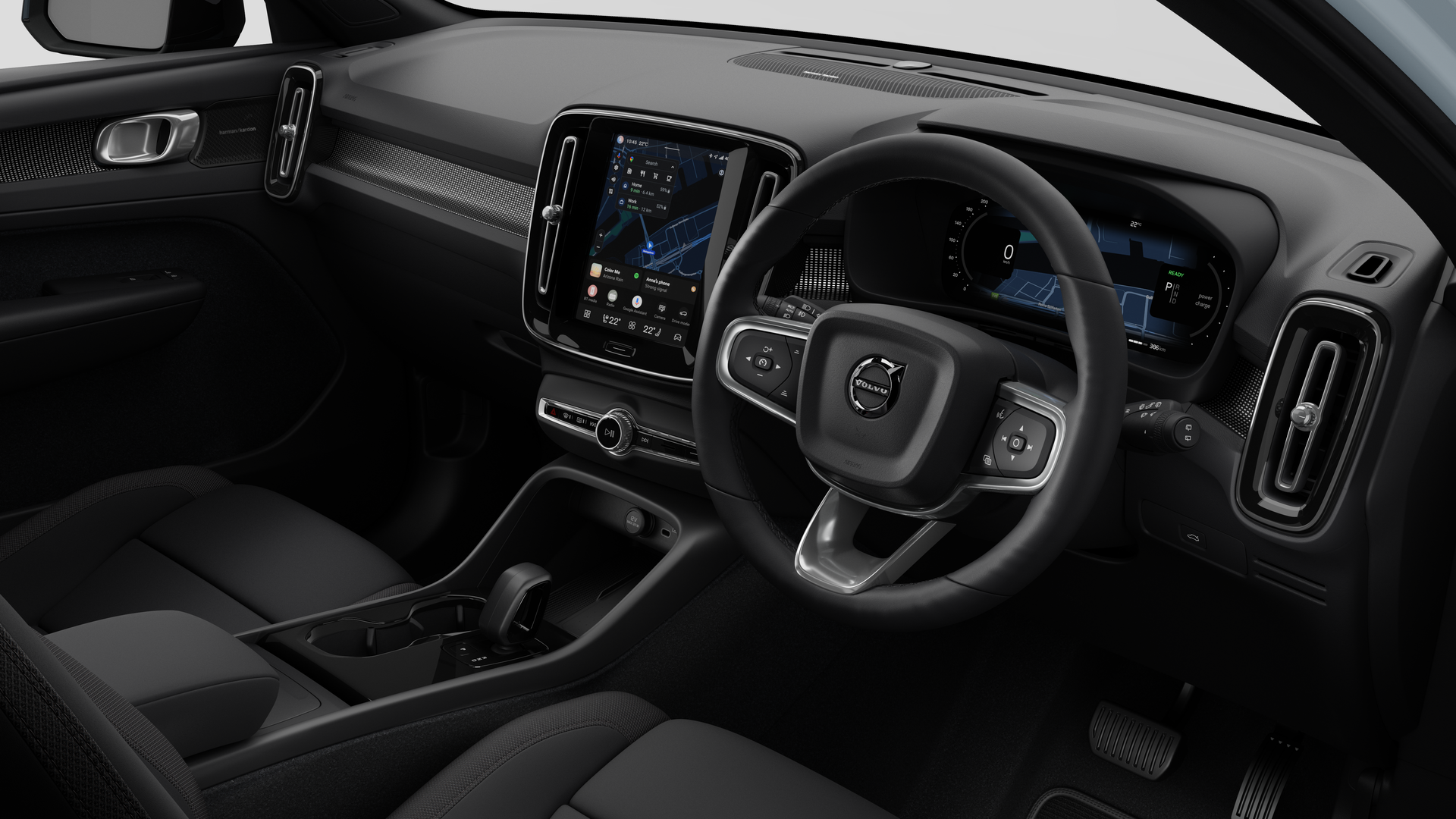 Interior view of a Volvo car showing the dashboard, steering wheel, center console, and digital display screen in a plain studio background.