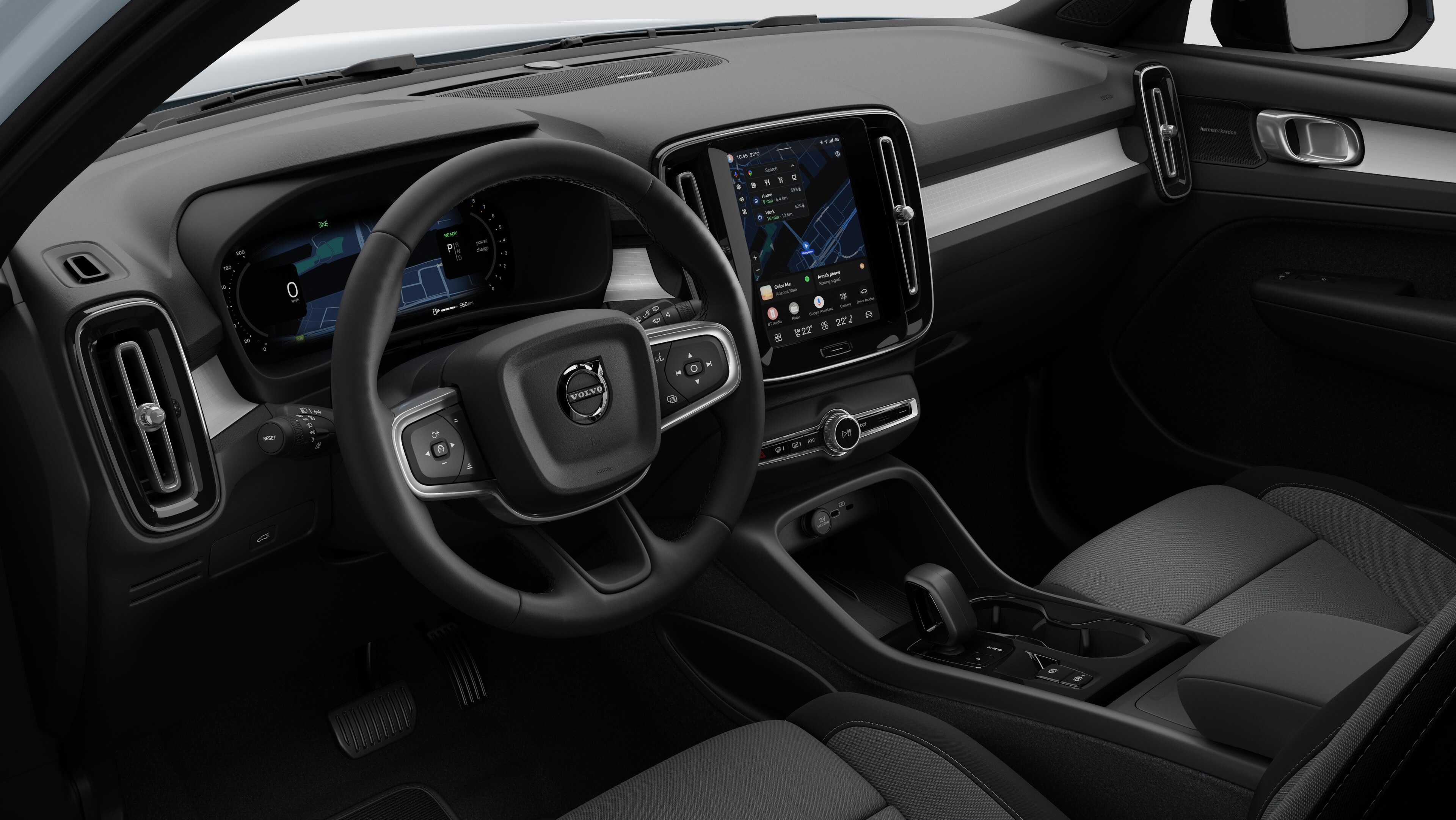 "Volvo" automobilio salono vaizdas, kuriame rodomas prietaisų skydelis, vairas, centrinė konsolė ir skaitmeninis ekranas paprastame studijos fone.