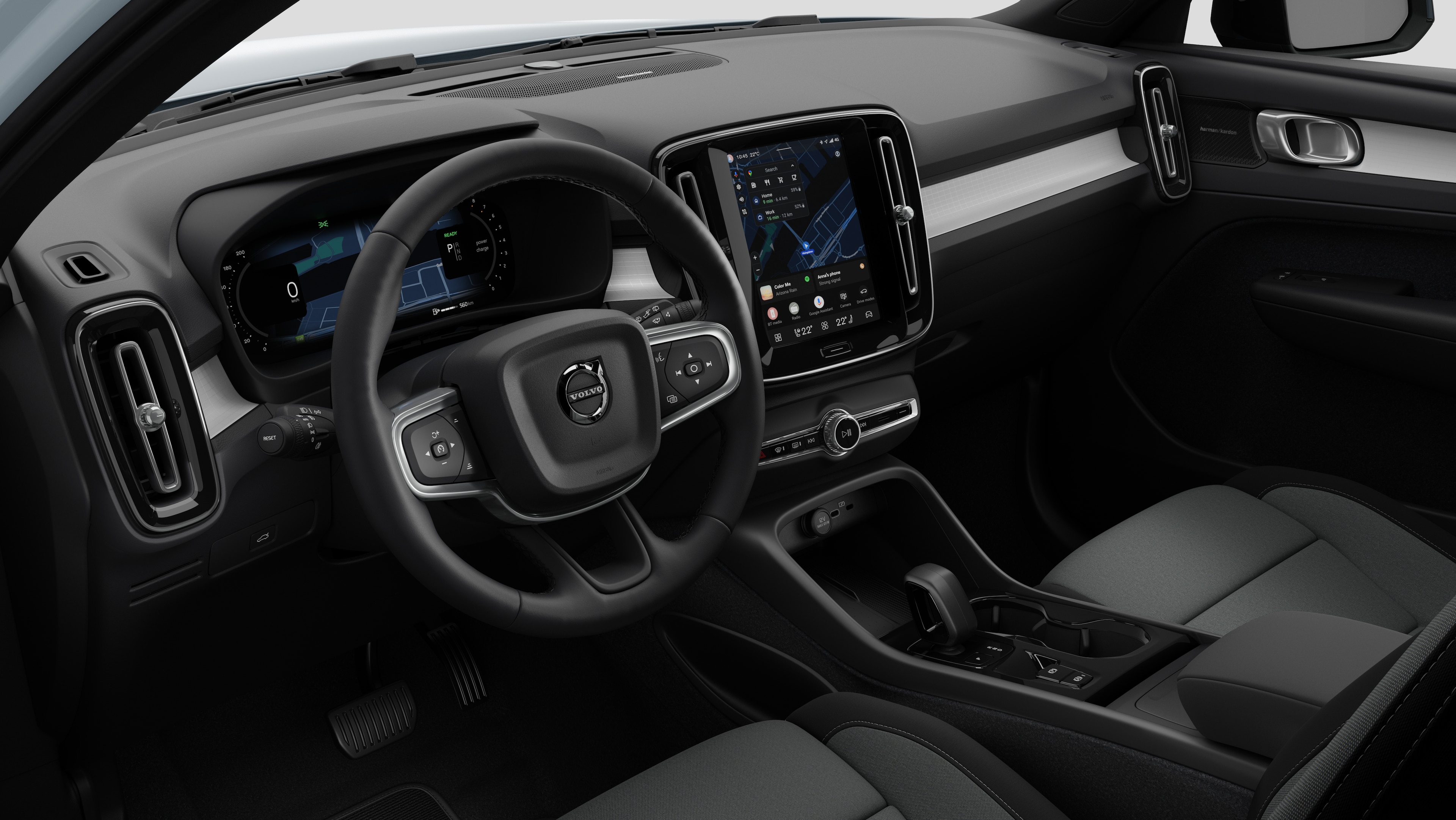 Volvo automašīnas salona skats, kurā redzams mērinstrumentu panelis, stūre, viduskonsole un digitālais displeja ekrāns vienkāršā studijas fonā.