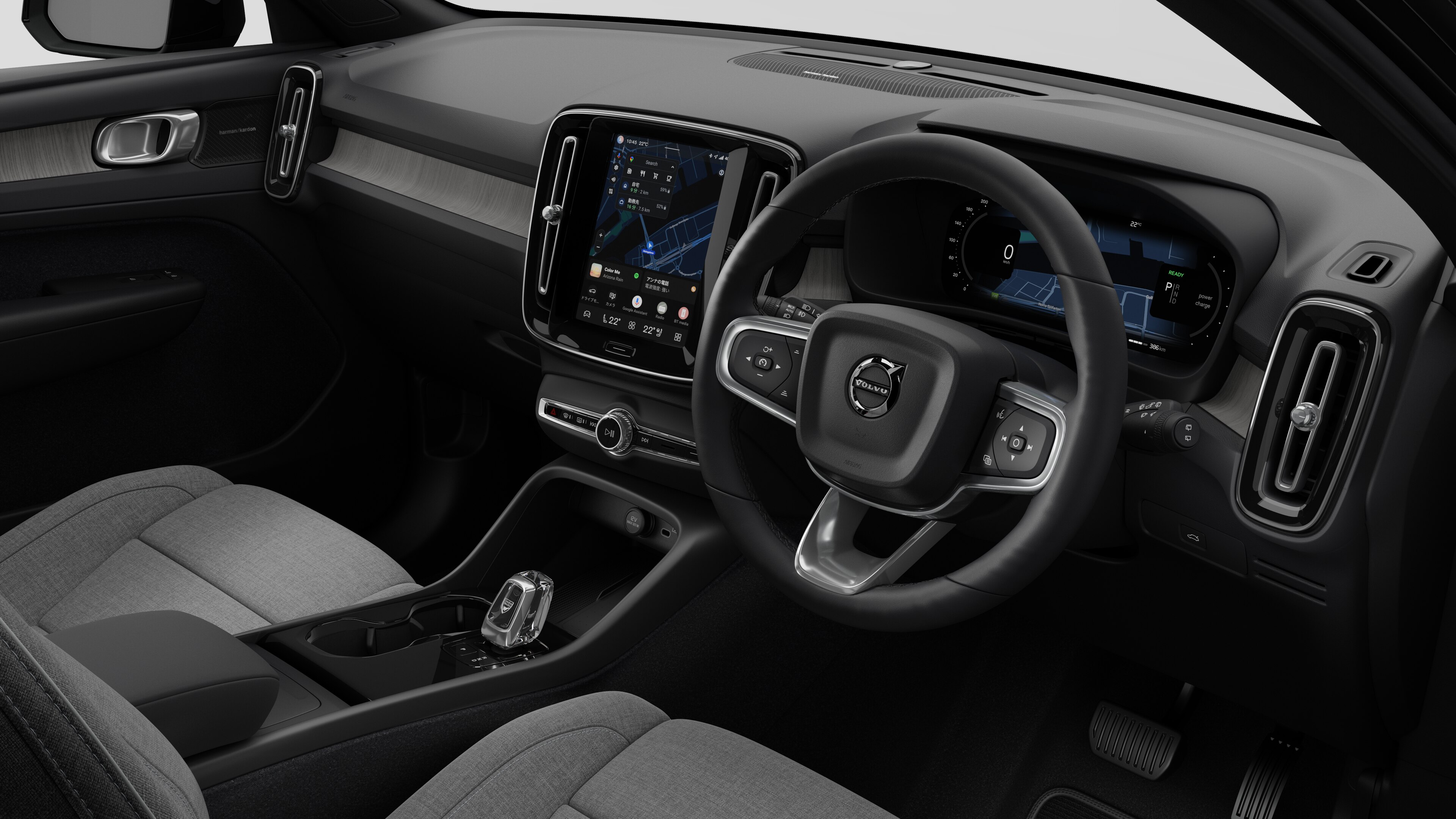 簡素なスタジオ背景にダッシュボード、ステアリングホイール、センターコンソール、デジタルディスプレイ画面を映し出すボルボ車のインテリア画像。