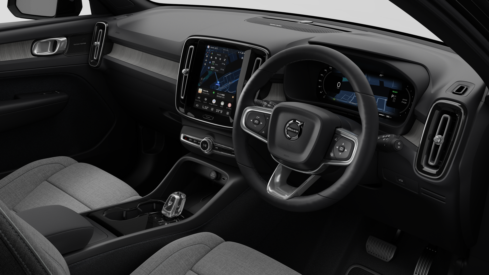 簡素なスタジオ背景にダッシュボード、ステアリングホイール、センターコンソール、デジタルディスプレイ画面を映し出すボルボ車のインテリア画像。