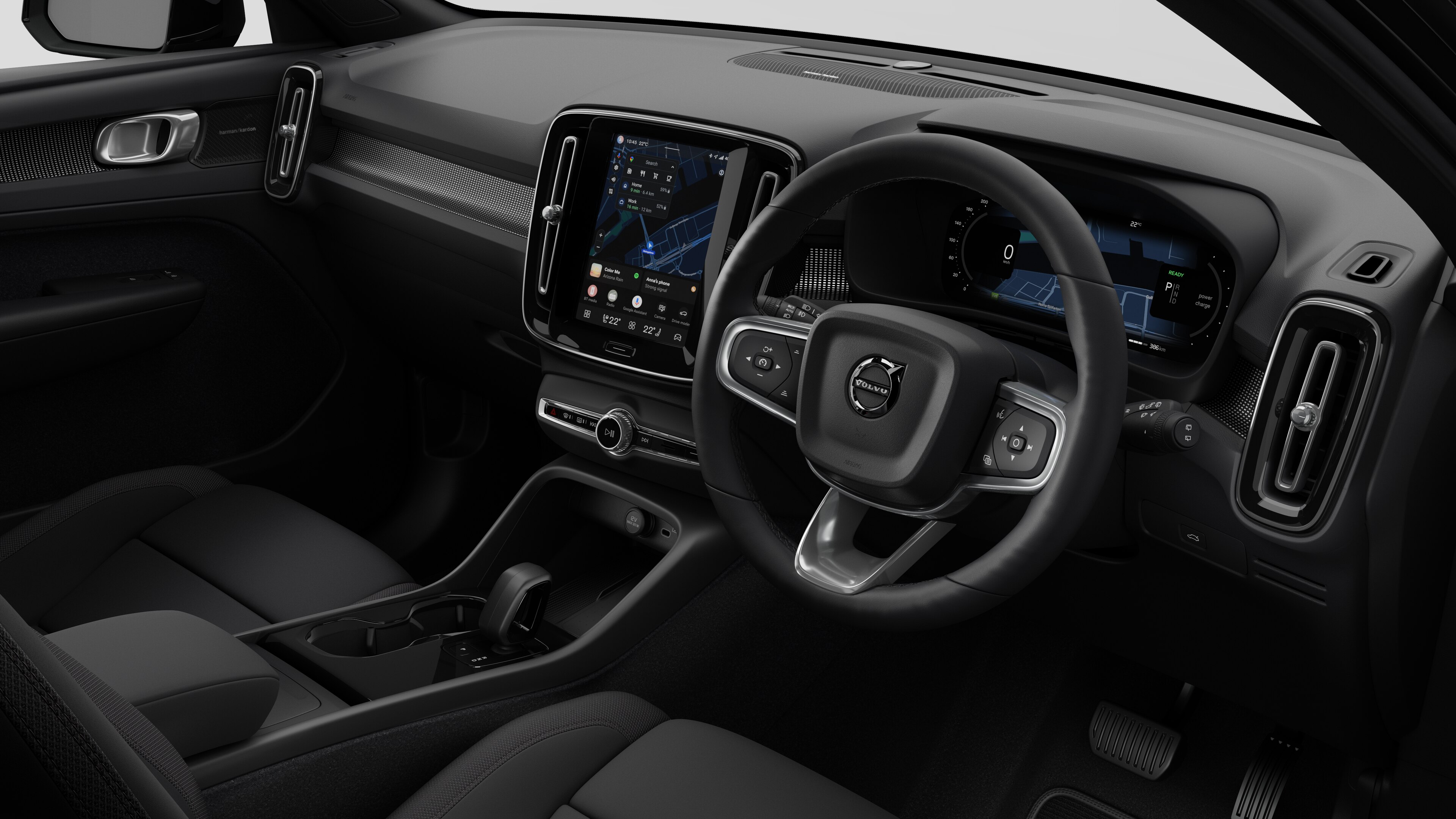 Interior view of a Volvo car showing the dashboard, steering wheel, center console, and digital display screen in a plain studio background.