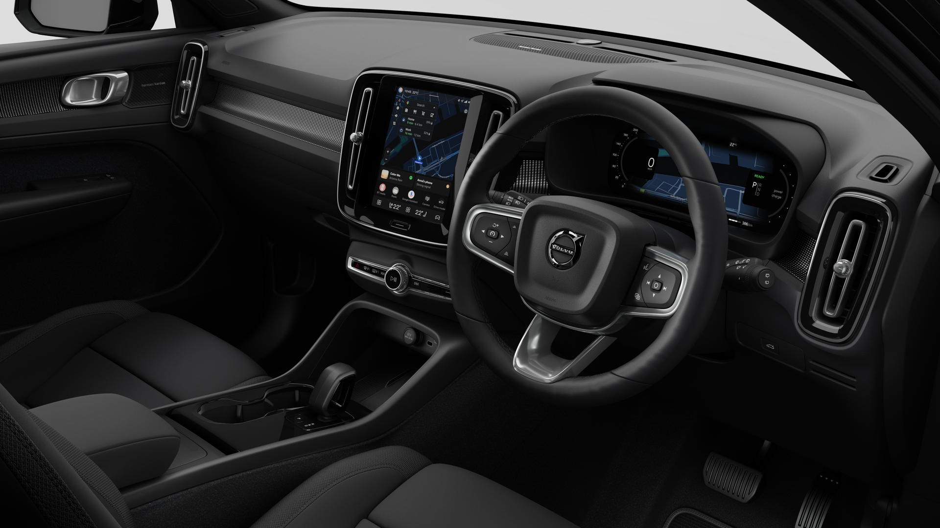 Interior view of a Volvo car showing the dashboard, steering wheel, center console, and digital display screen in a plain studio background.