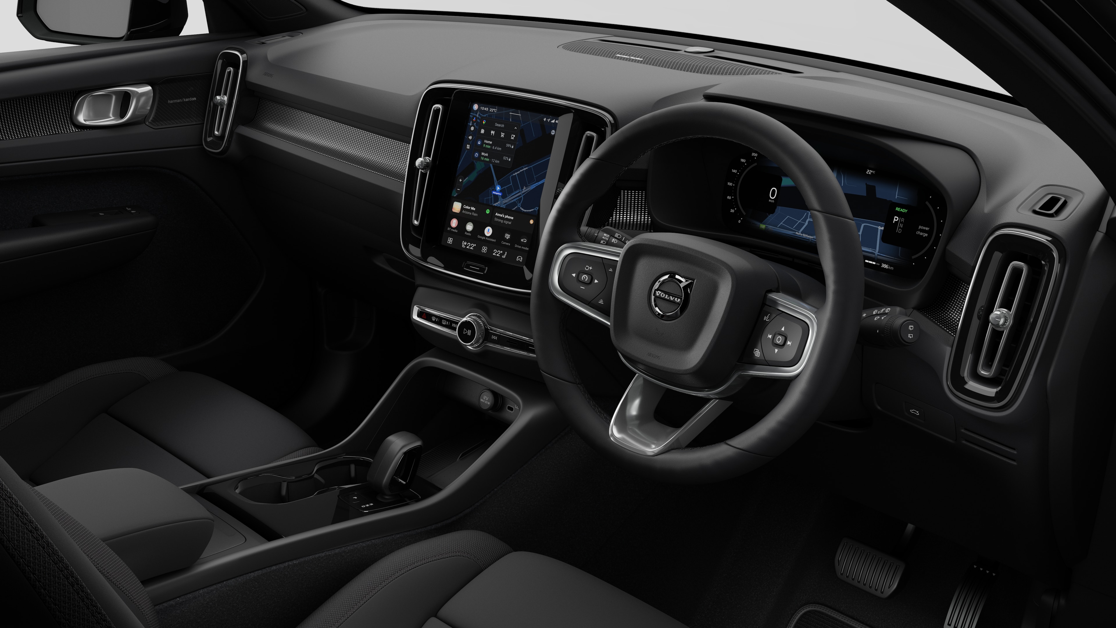 Interior view of a Volvo car showing the dashboard, steering wheel, center console, and digital display screen in a plain studio background.