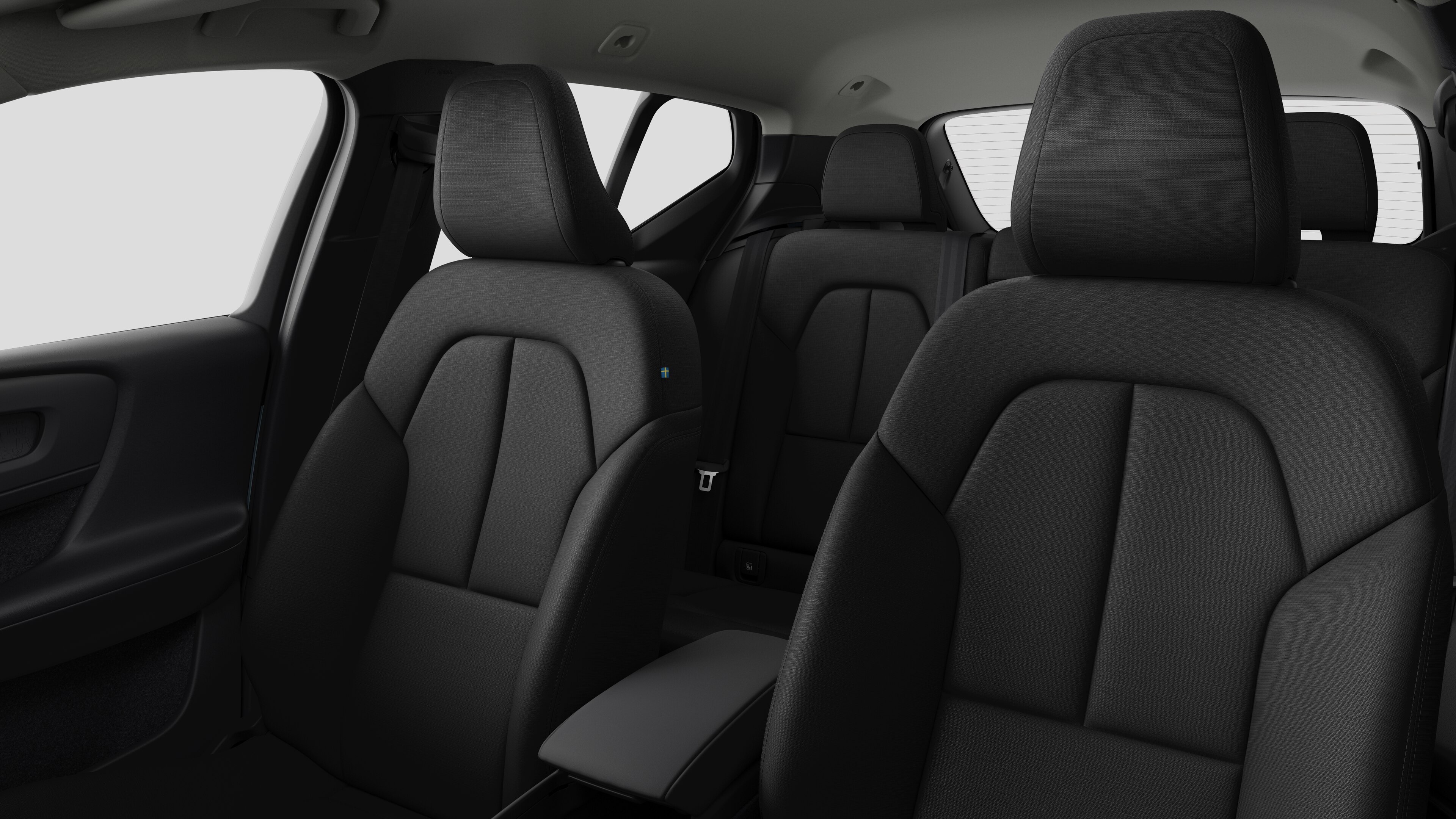 Het interieur van een Volvo met de passagiersstoelen achterin en de middenconsole in een effen studioachtergrond.