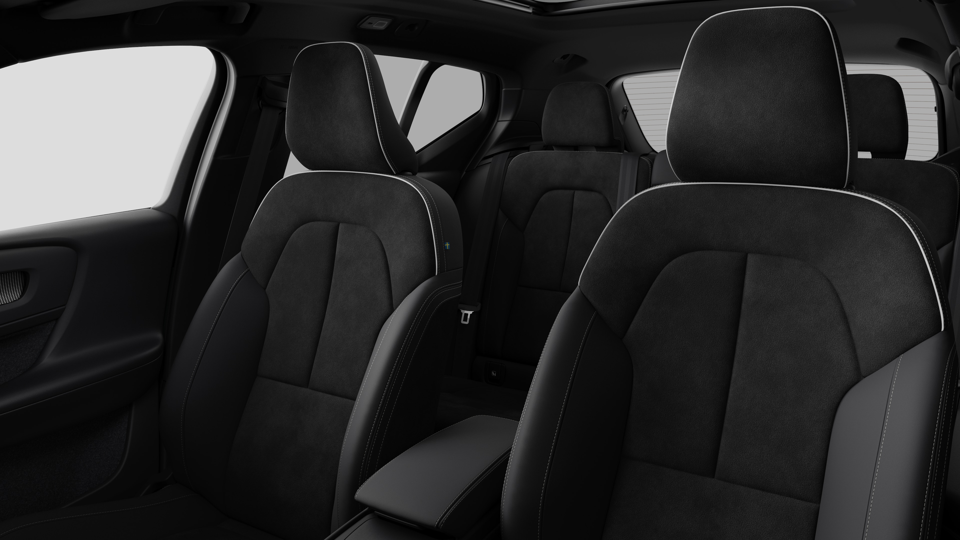Interieur van de Volvo met de passagiersstoelen achteraan en de middenconsole op een effen studioachtergrond.