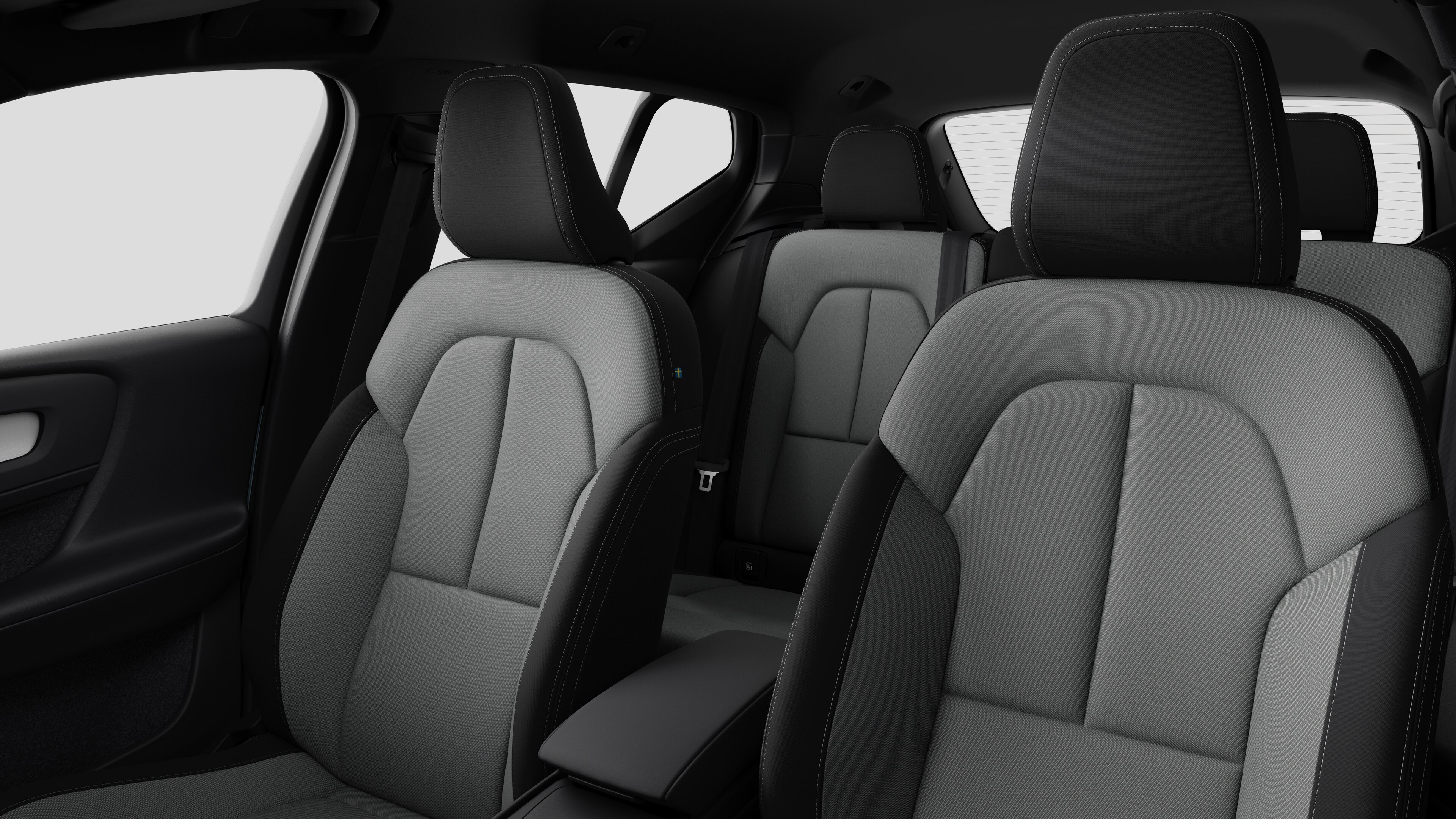 Volvo მანქანის ინტერიერი, რომელიც აჩვენებს უკანა სამგზავრო სავარძლებს და ცენტრალურ კონსოლს უბრალო სტუდიის ფონზე.