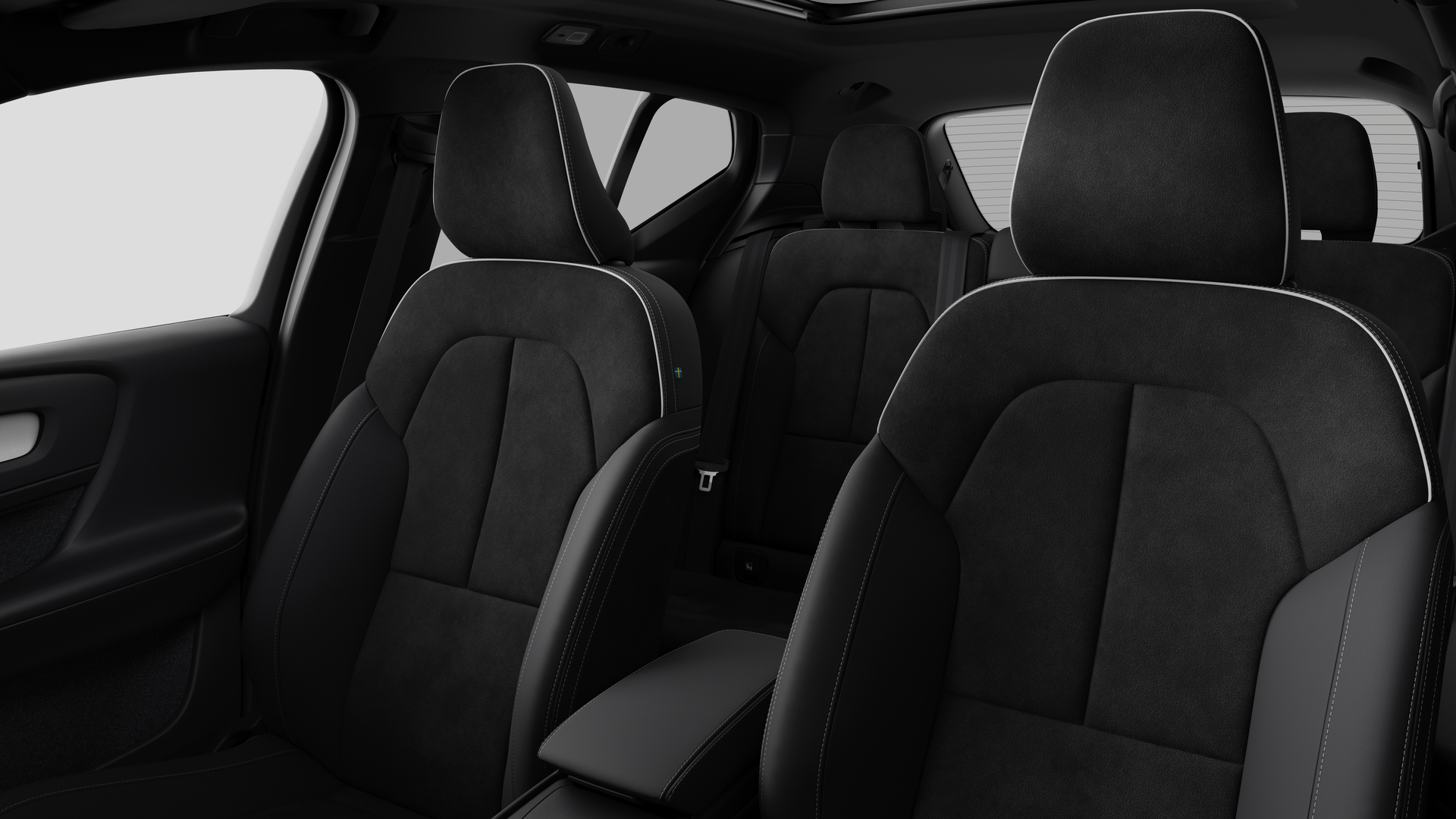 Interieur van de Volvo met de passagiersstoelen achteraan en de middenconsole op een effen studioachtergrond.