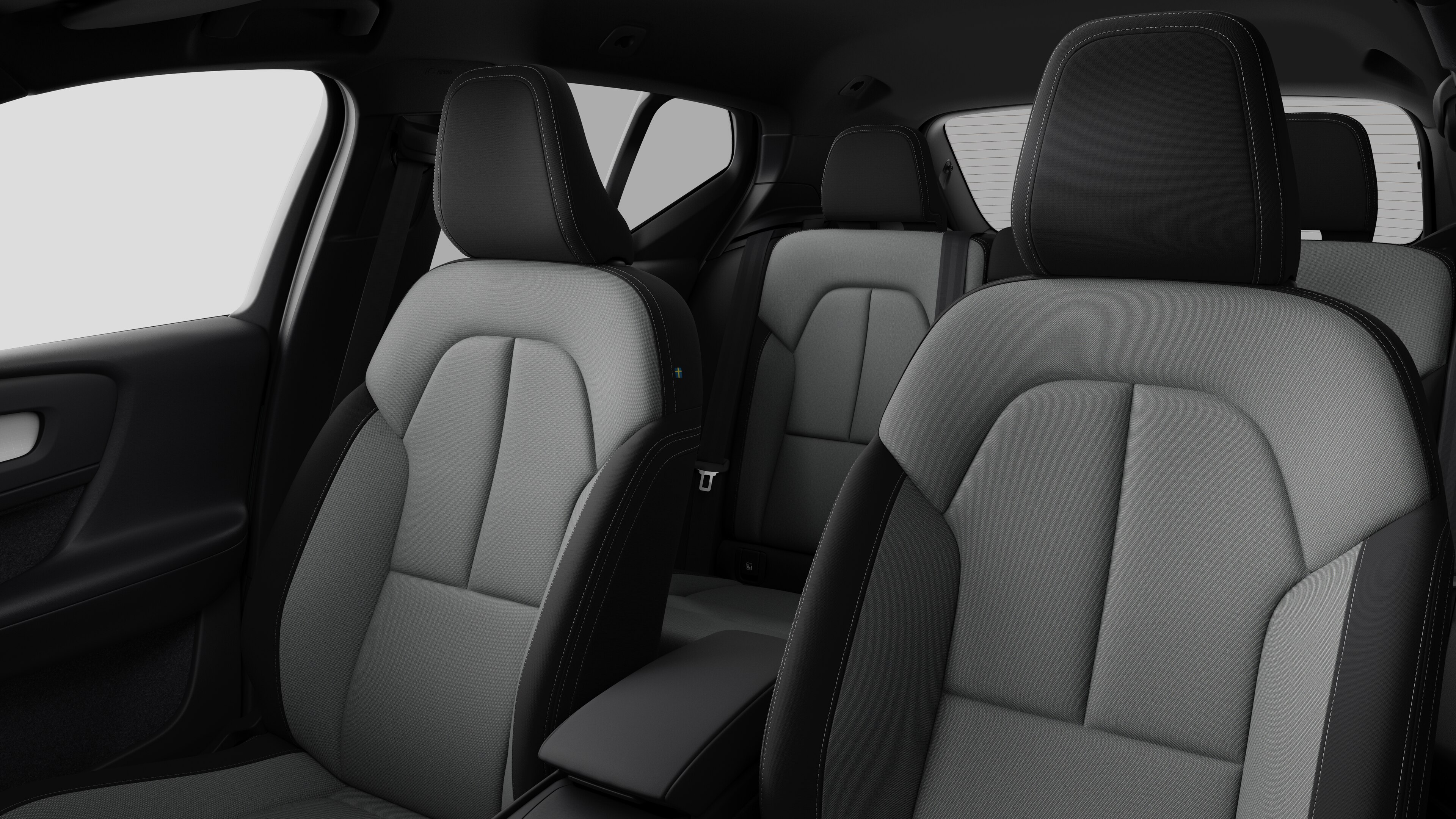 Interieur van de Volvo met de passagiersstoelen achteraan en de middenconsole op een effen studioachtergrond.