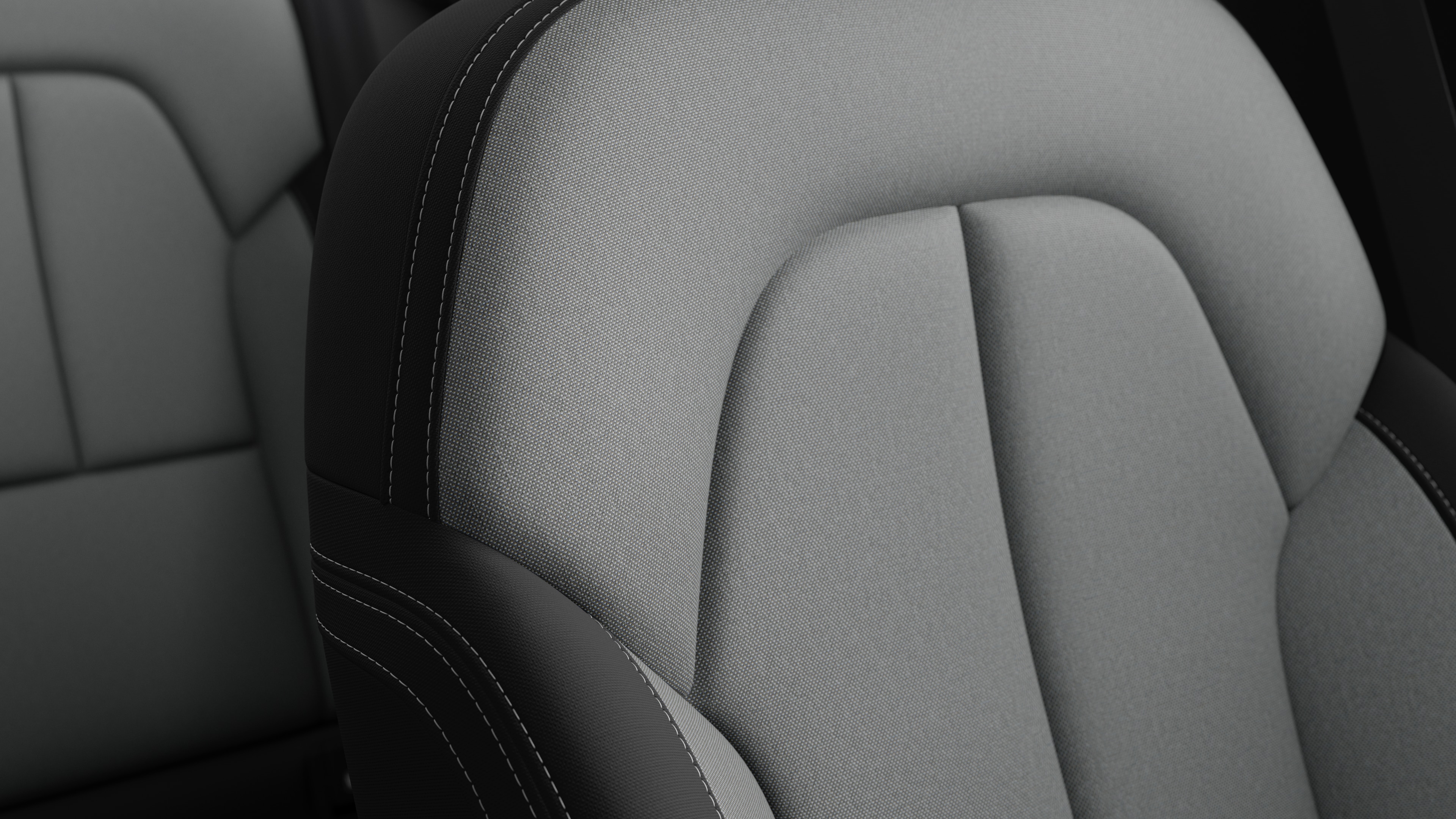 Close-up of Volvo car interior seat detail showing stitching and a small Swedish flag tag.