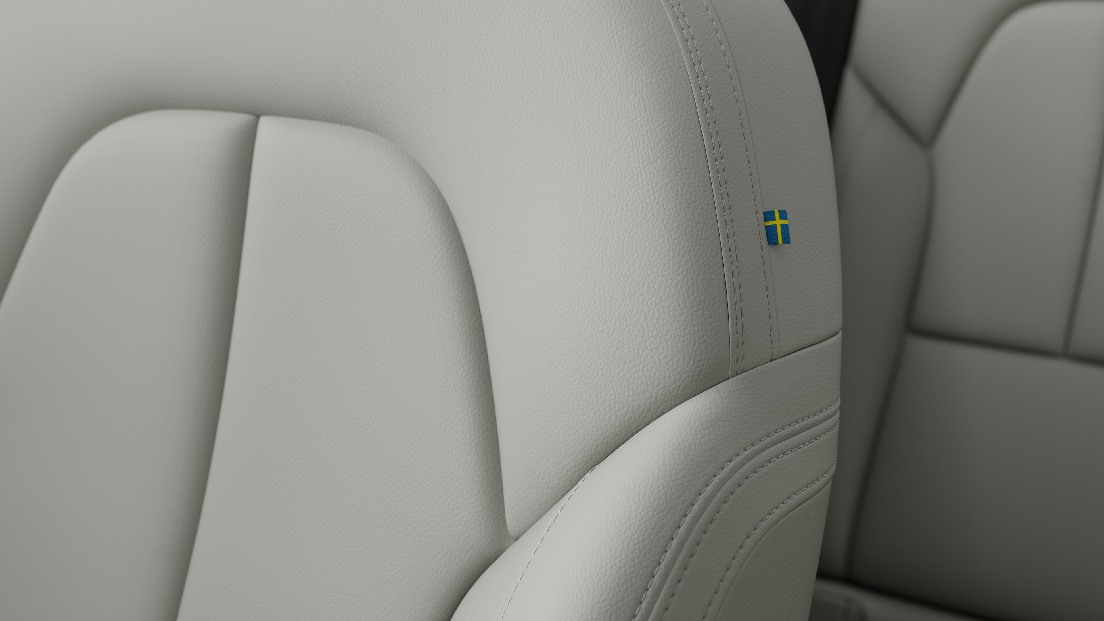 스티칭과 작은 스웨덴 국기 태그를 보여주는 볼보 자동차 내부 시트 디테일 클로즈업.