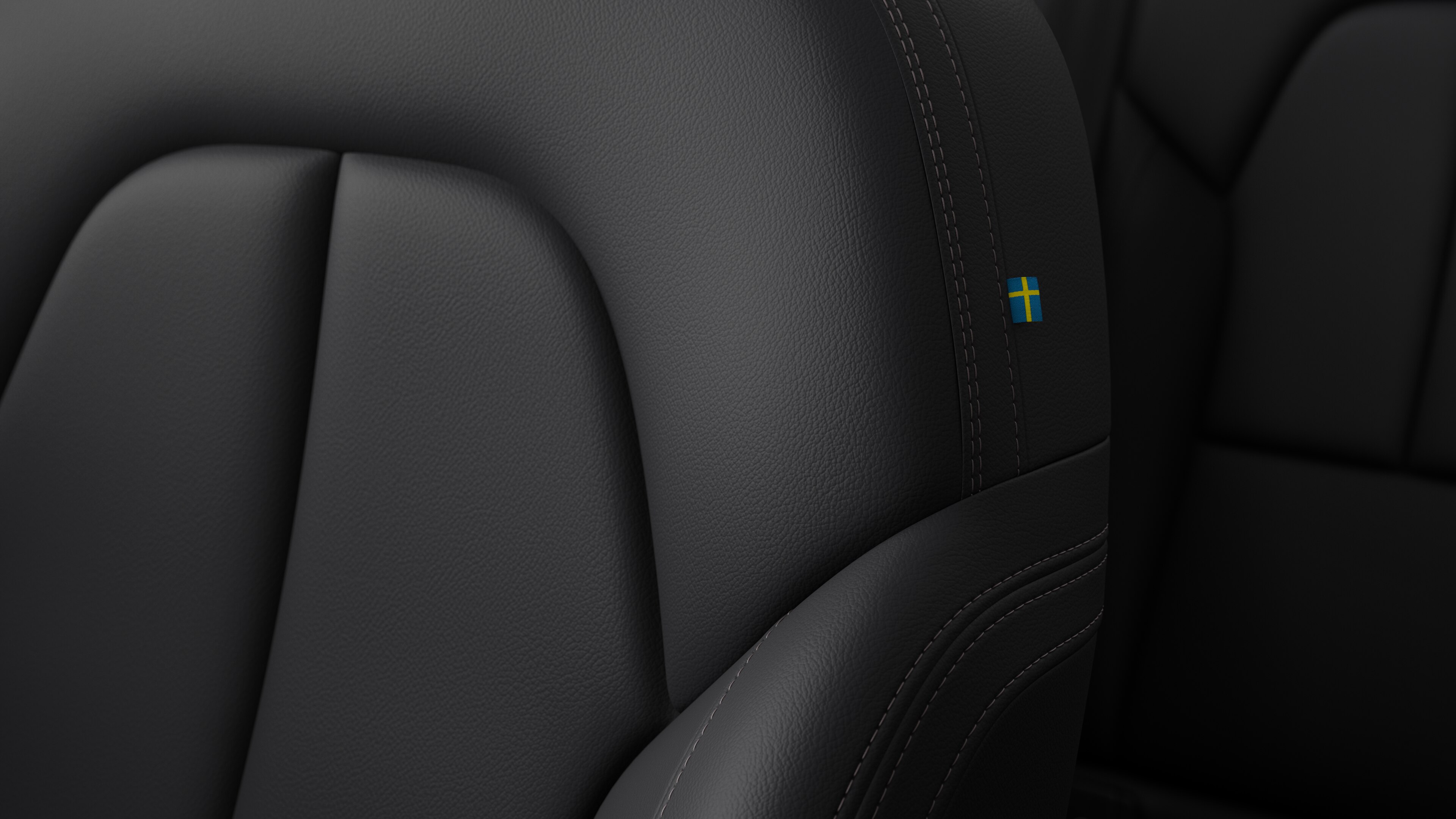 Gros plan sur un siège Volvo montrant des surpiqûres et un petit drapeau suédois.