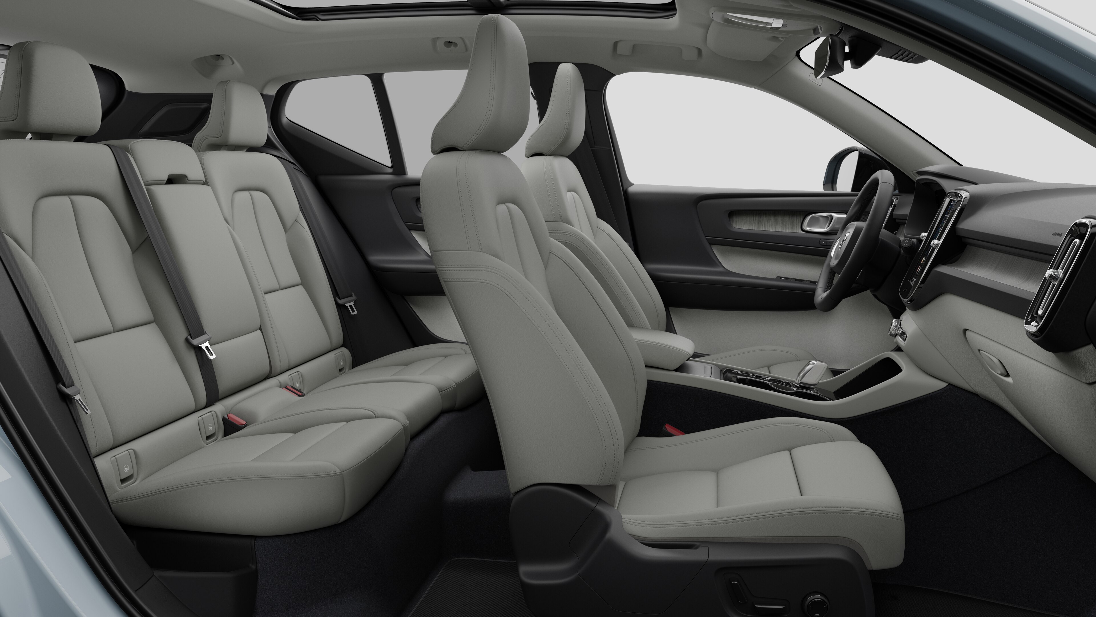 Volvo car interior side view showcasing front seats, rear passenger seats, steering wheel, dashboard, and center console, set against plain studio background.