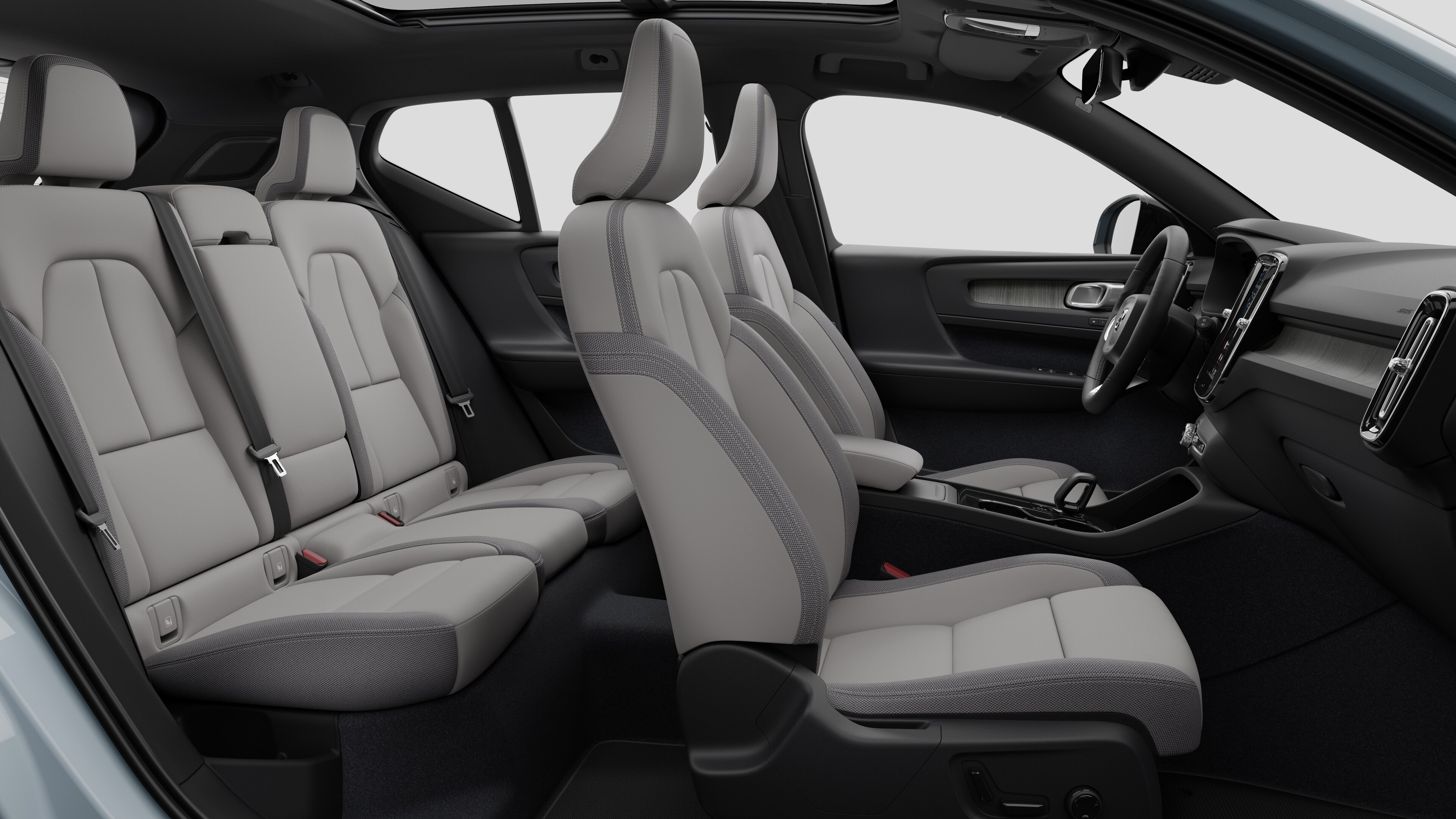 Volvo car interior side view showcasing front seats, rear passenger seats, steering wheel, dashboard, and center console, set against plain studio background.