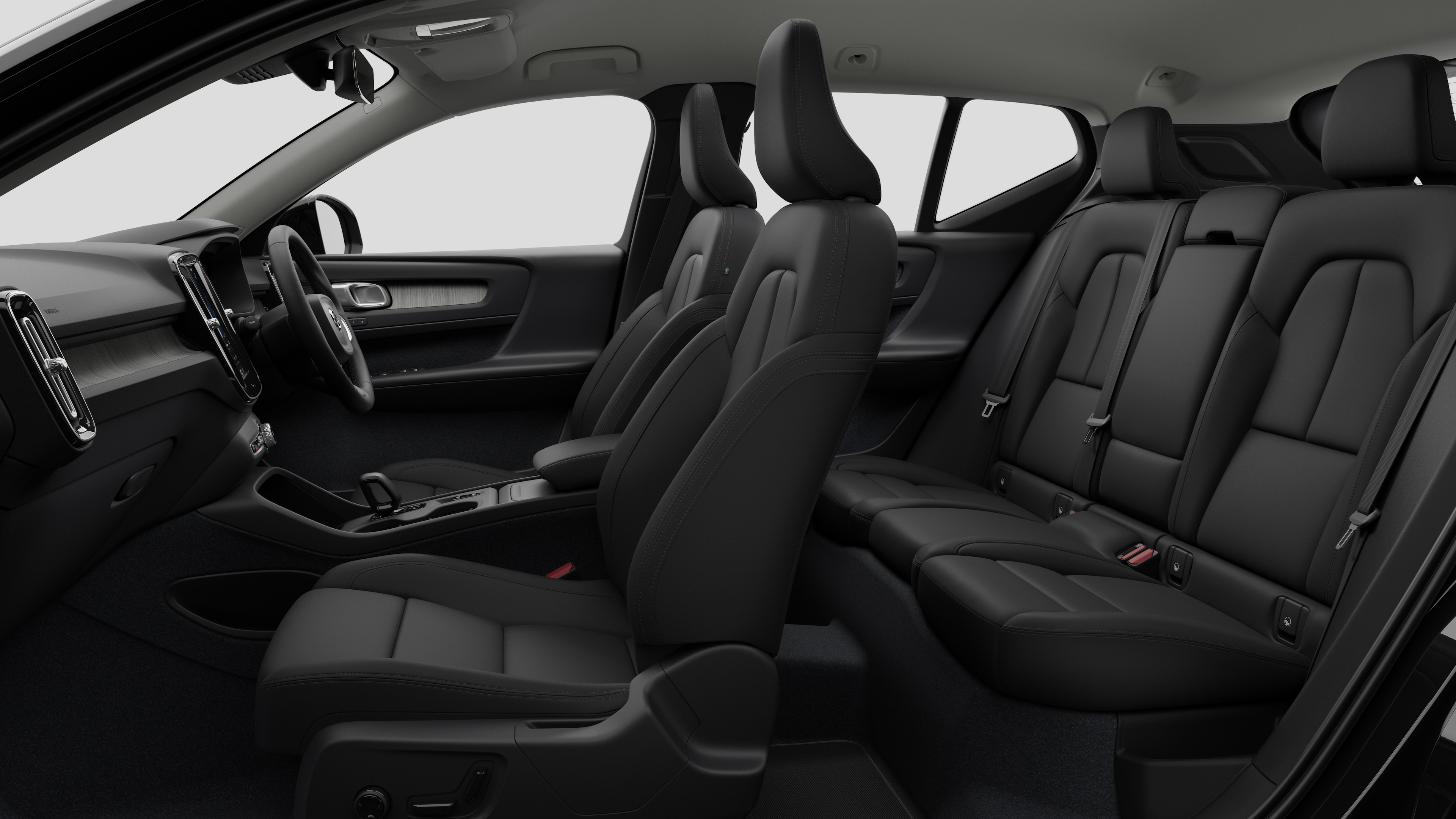 Volvo car interior side view showcasing front seats, rear passenger seats, steering wheel, dashboard, and center console, set against plain studio background.