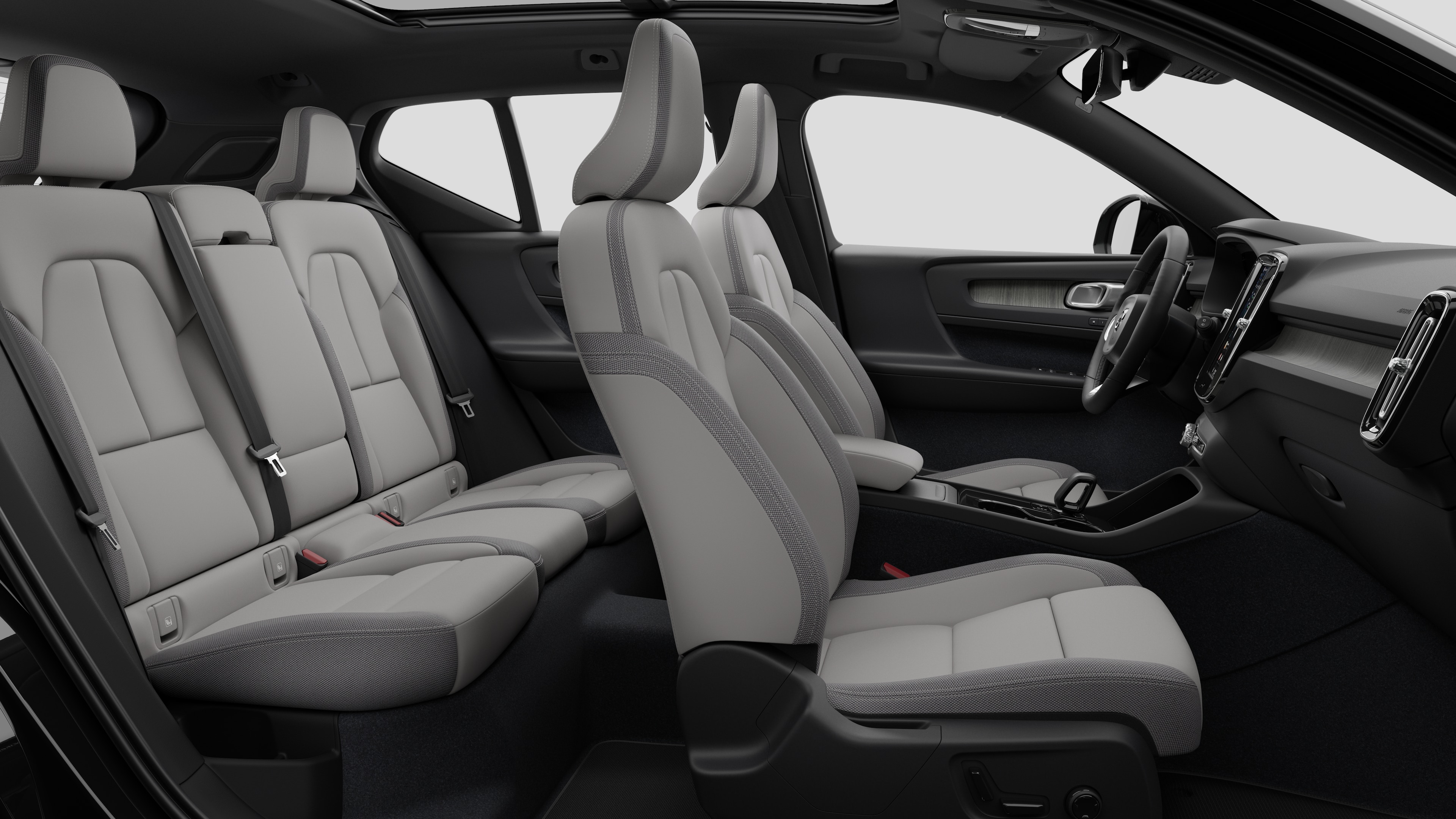 Vista lateral do interior do carro Volvo mostrando os bancos dianteiros, traseiros do passageiro, volante, painel de instrumentos e console central, contra um plano de fundo de estúdio simples.