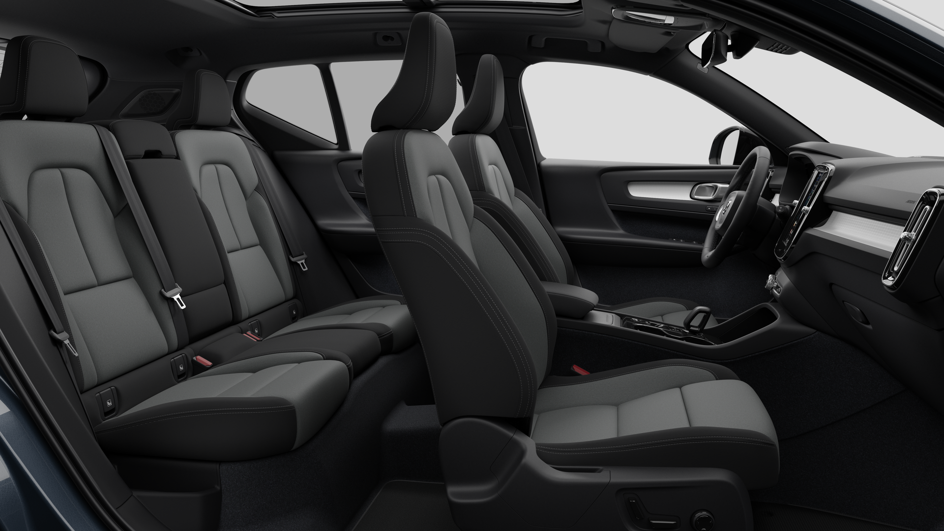 Vue latérale de l’intérieur d’une Volvo montrant les sièges avant, les sièges passager arrière, le volant, le tableau de bord et la console centrale, sur fond de studio.