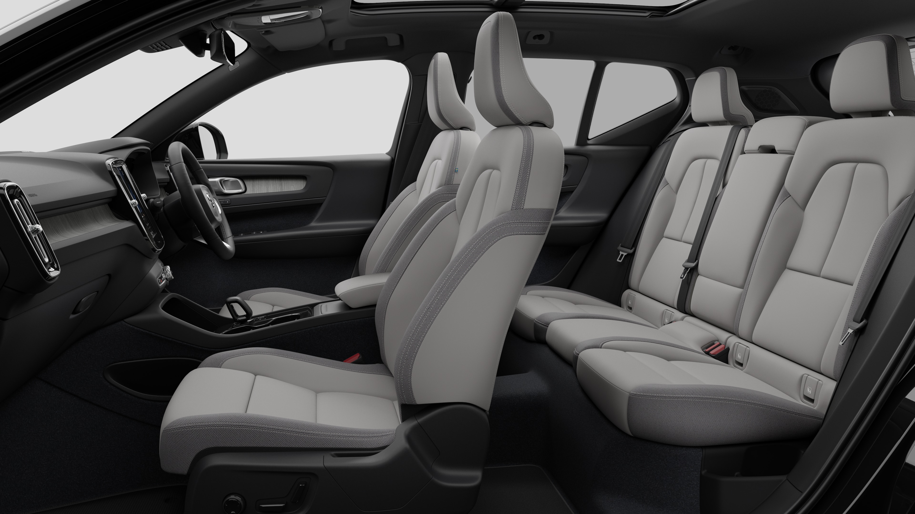 Volvo car interior side view showcasing front seats, rear passenger seats, steering wheel, dashboard, and center console, set against plain studio background.