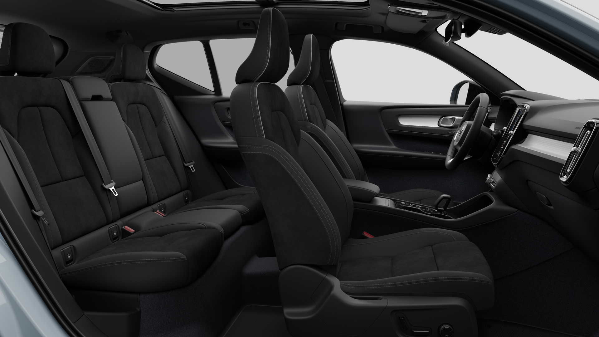 Vue latérale de l’intérieur d’une Volvo montrant les sièges avant, les sièges passager arrière, le volant, le tableau de bord et la console centrale, sur fond de studio.