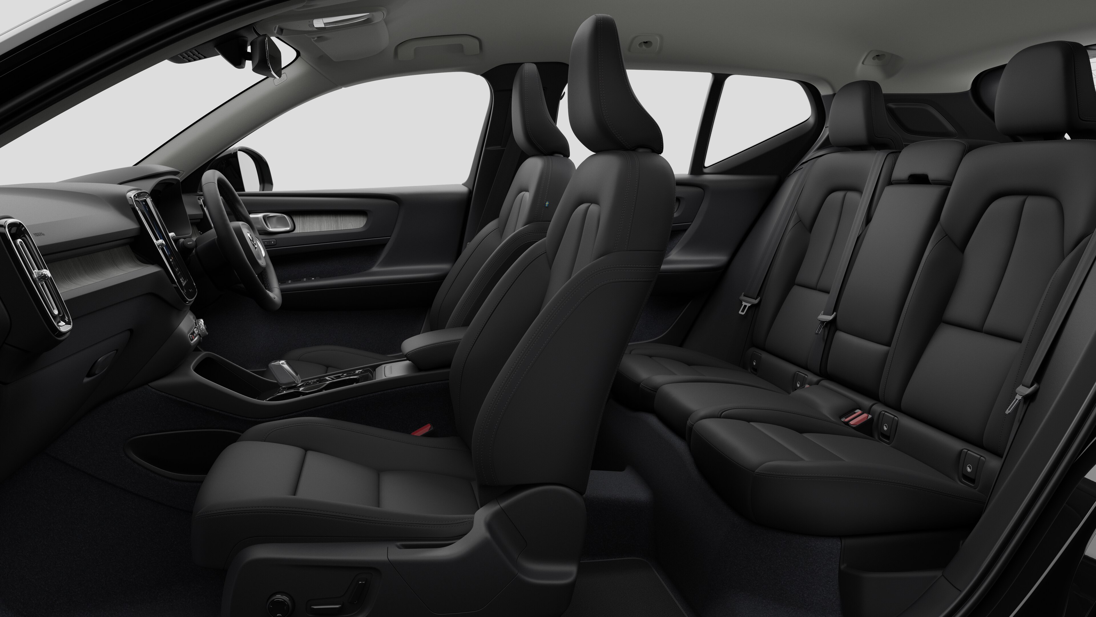 Volvo car interior side view showcasing front seats, rear passenger seats, steering wheel, dashboard, and center console, set against plain studio background.