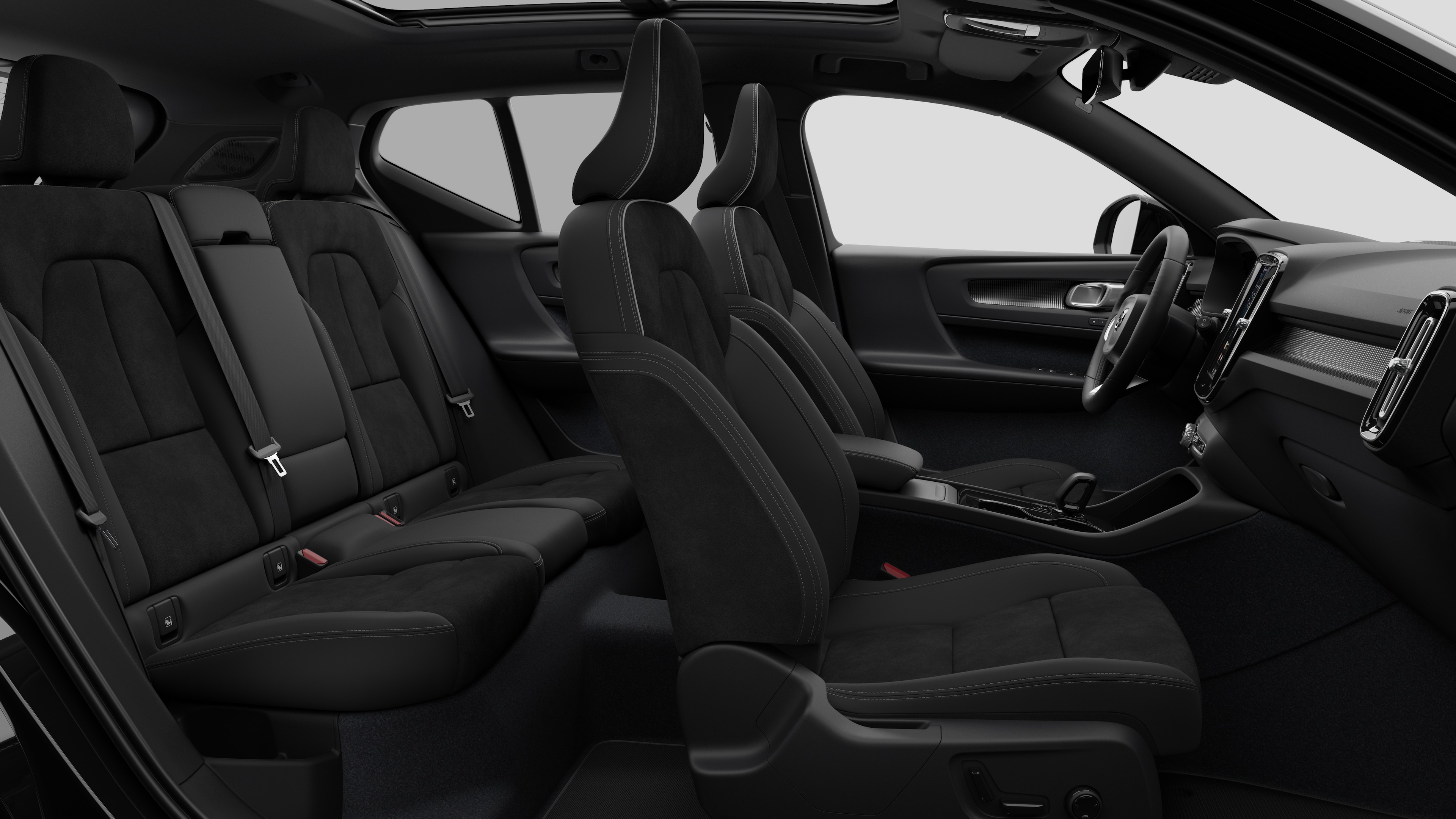 Vue latérale de l’intérieur d’une Volvo montrant les sièges avant, les sièges passager arrière, le volant, le tableau de bord et la console centrale, sur un fond de studio uni.