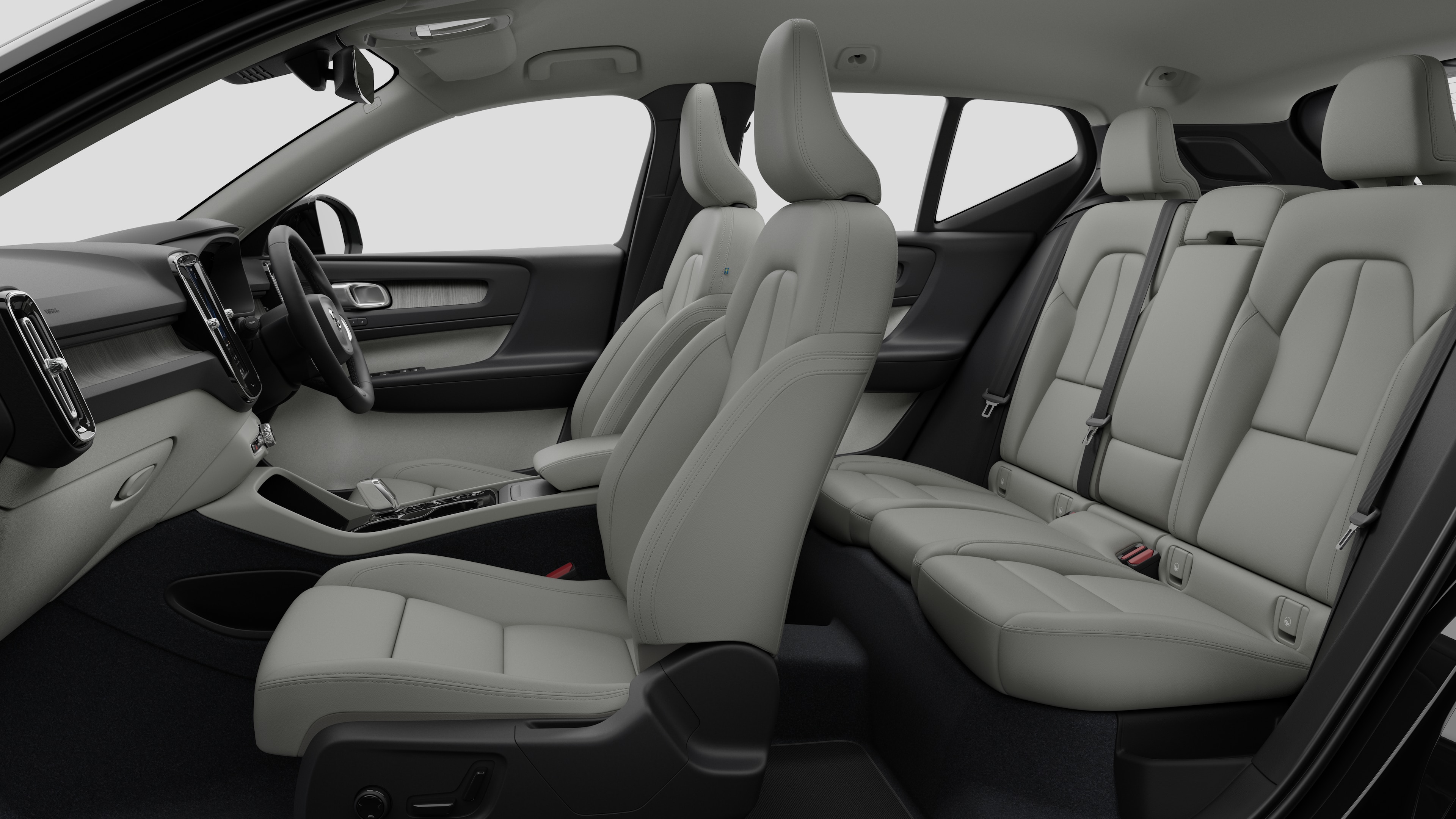 Volvo car interior side view showcasing front seats, rear passenger seats, steering wheel, dashboard, and center console, set against plain studio background.